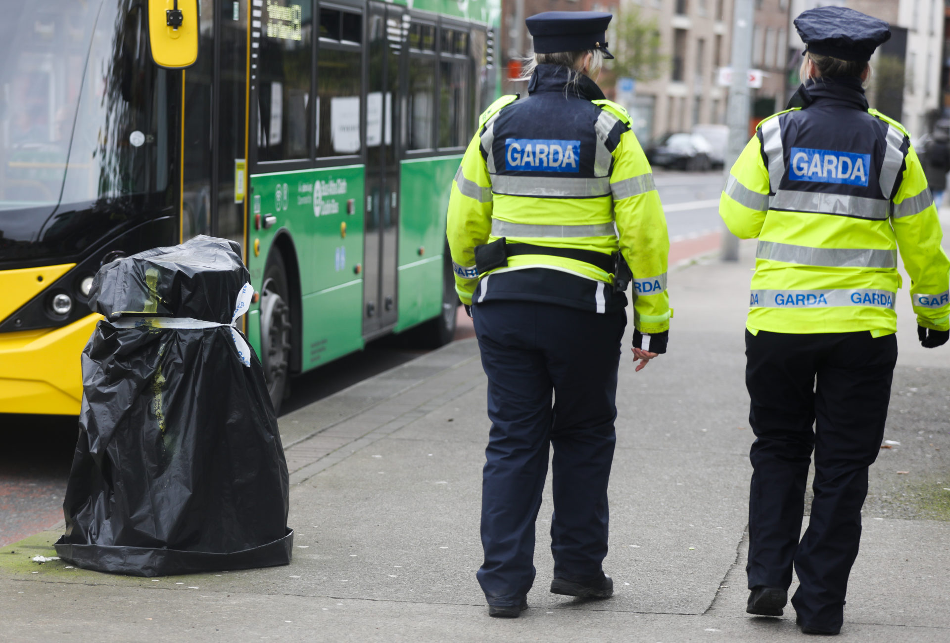 Gardaí passing a litter bin which has been taped closed as extra security precautions are put in place ahead of the visit of US President Joe Biden