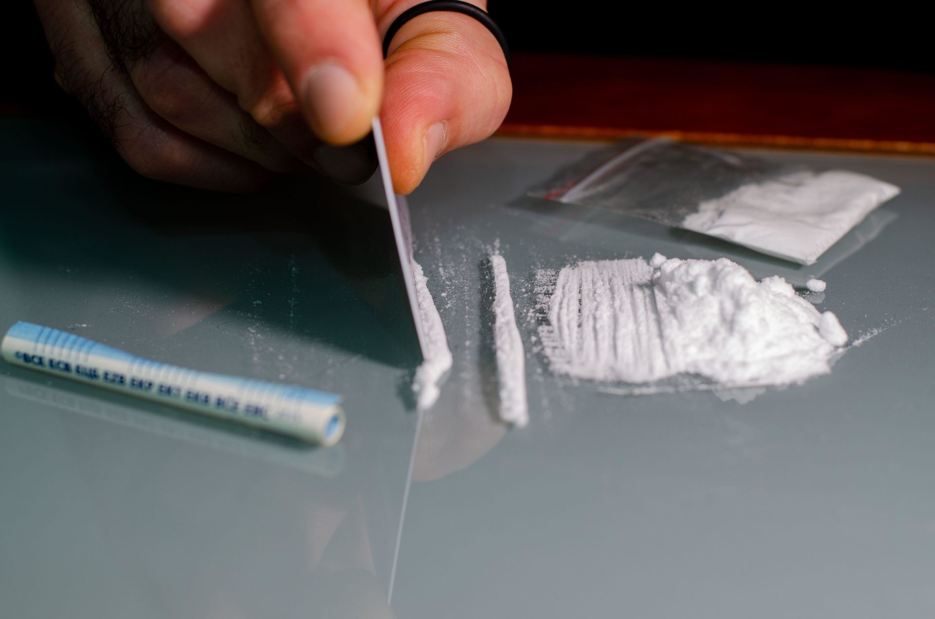 A man divides the cocaine into strips and then snorts.