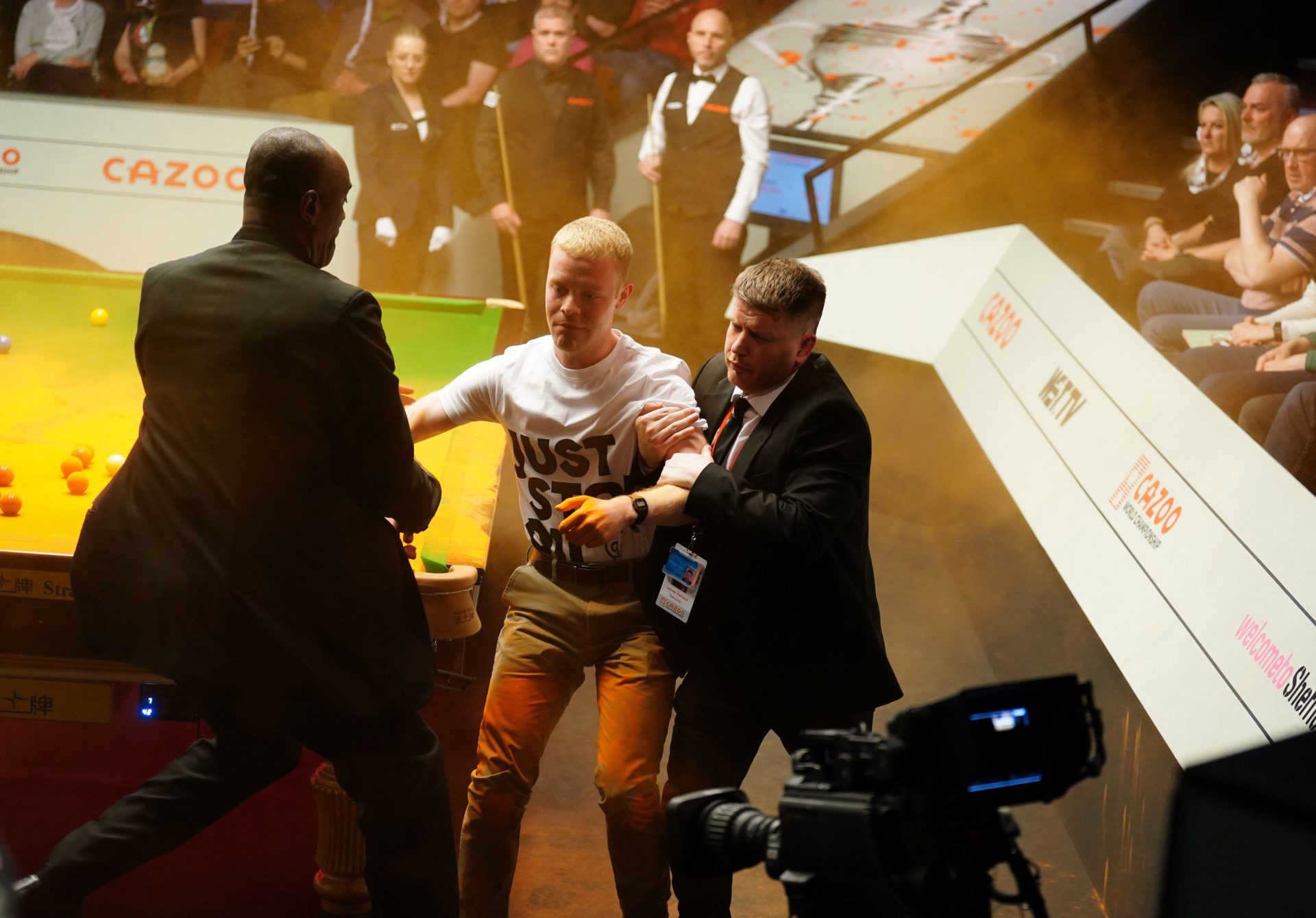 A Just Stop Oil protester is removed after throwing orange powder on a snooker table during the World Snooker Championship in Sheffield