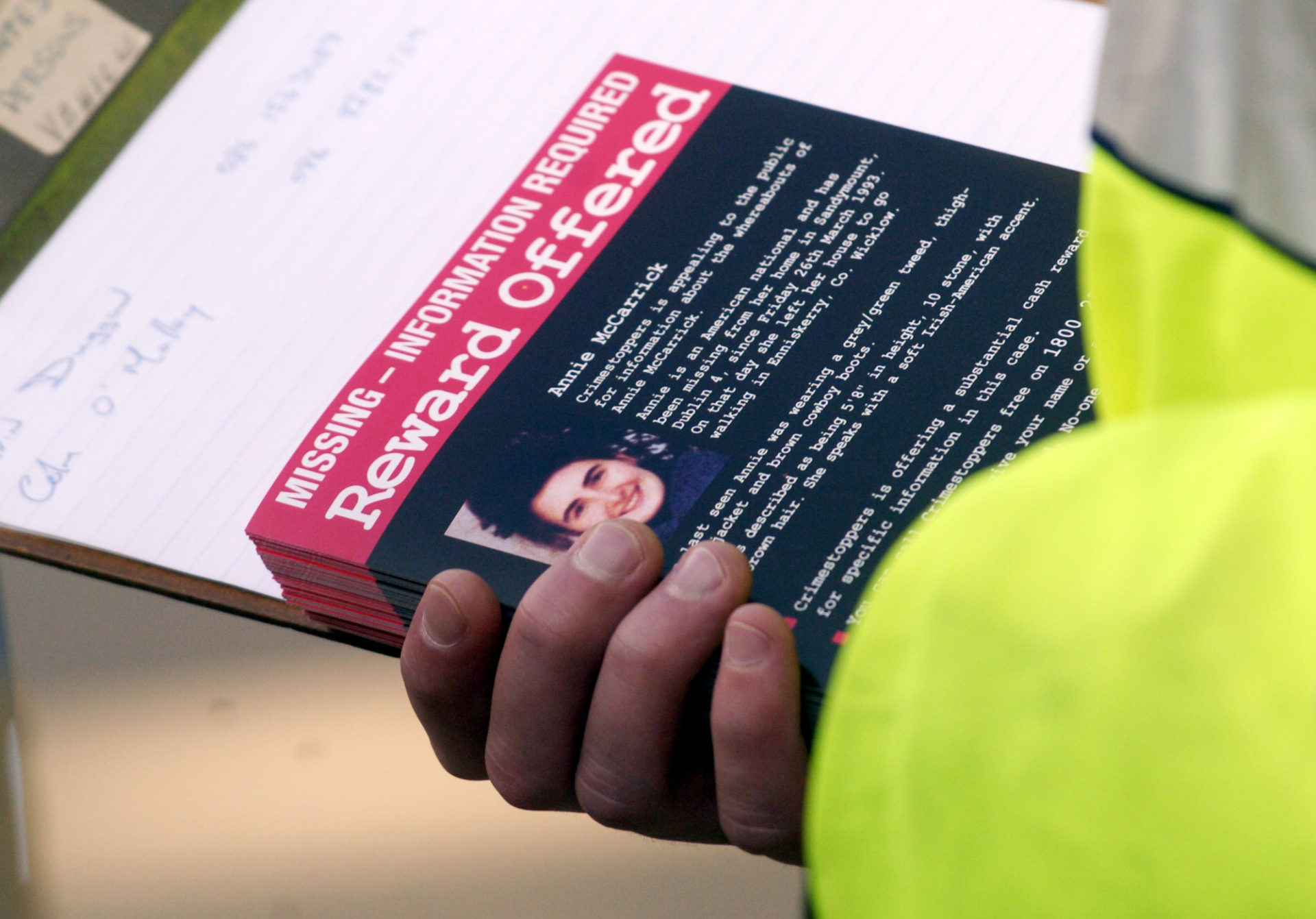 A member of the Gardai hands out leaflets, Sandymount Village, Dublin, with the photo of Annie McCarrick who went missing from Sandymount twelve years ago in the hope of refreshing the publics memory in this new campaign by the Gardai and Crimestoppers. 