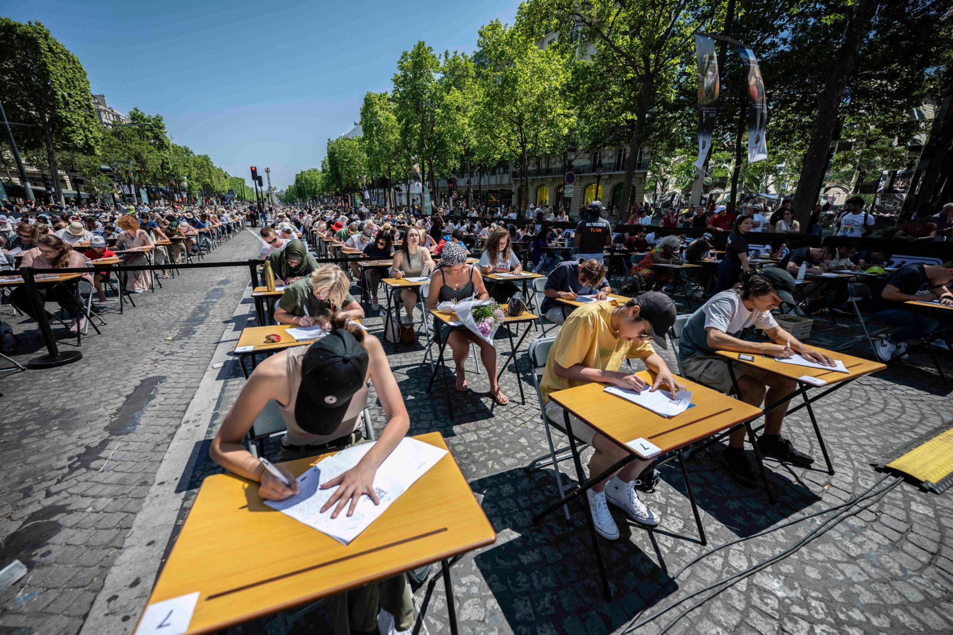 People participate in 'The World's Biggest Dictation' on the Champs Elysees in Paris, France on June 4th, 2023