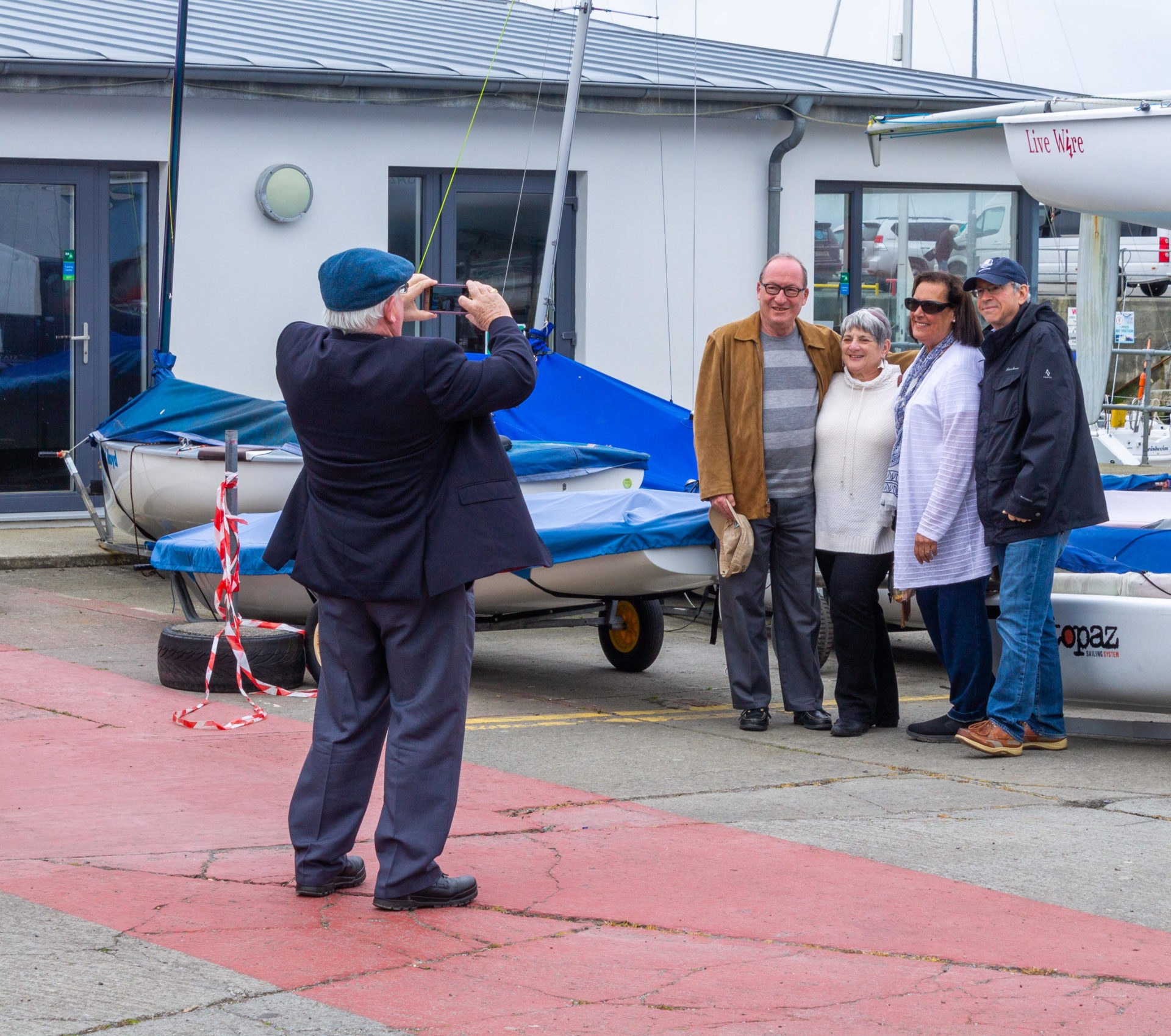Tourists having their photographs taken by another american tourist outside baltimore yacht club in ireland.