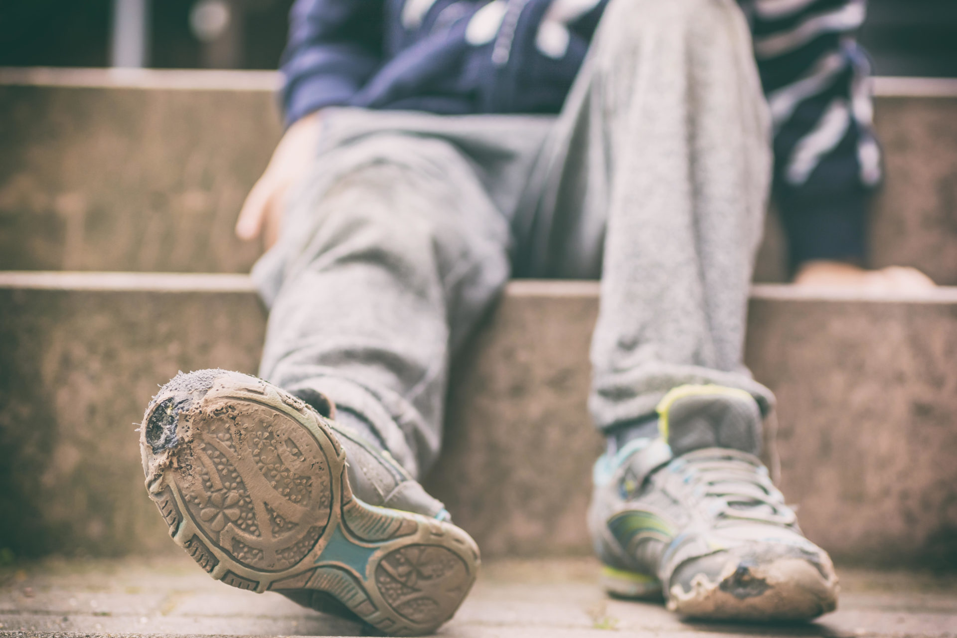 WT5TW5 Old broken shoes of a little boy as a symbol for child poverty