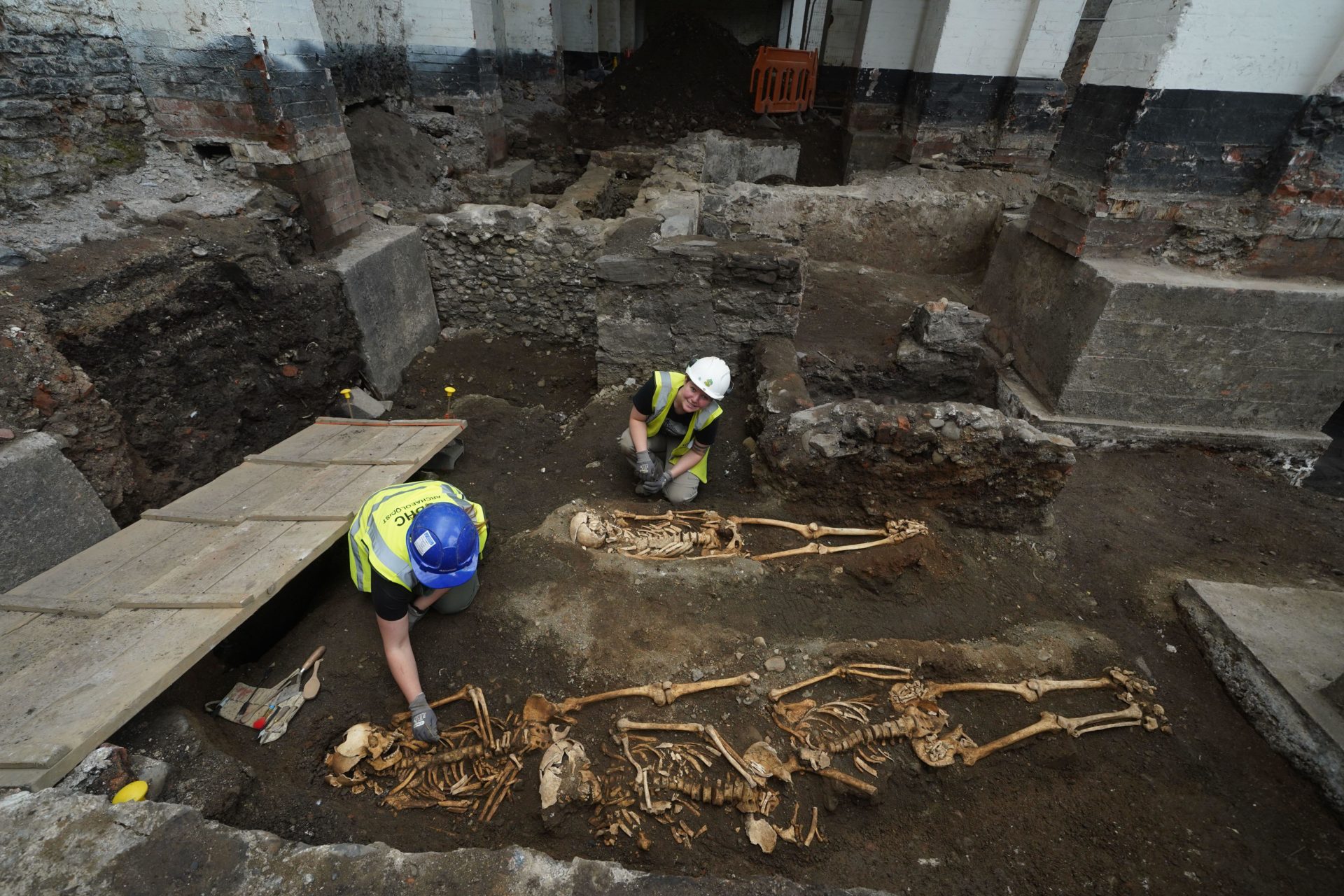 Members of the archaeology team works on a skeleton at an ancient burial site associated with the earliest inhabitants of medieval Dublin, which has been discovered along with foundations of buildings dating back to the 1600s, during preparatory works for