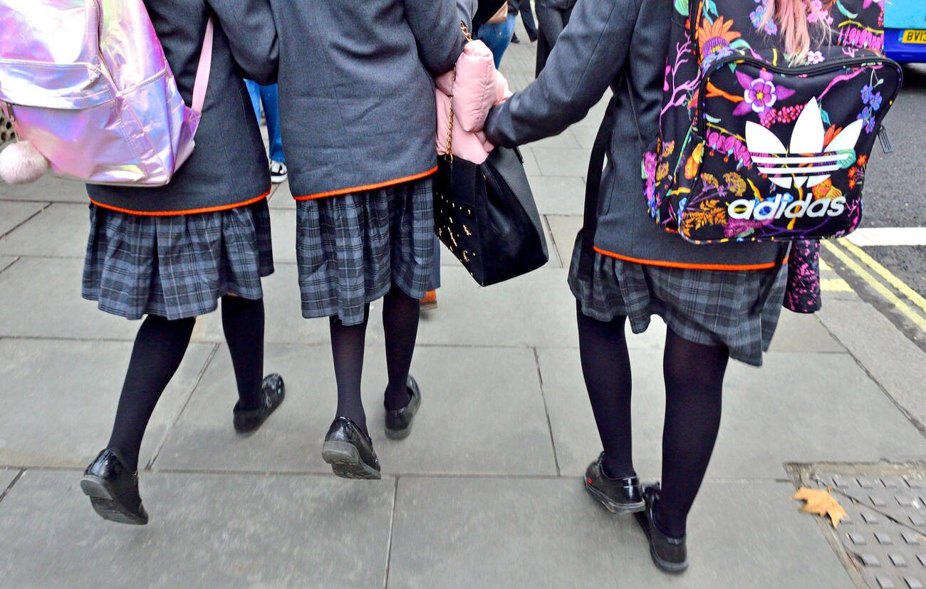 A group of school children walking in their uniforms.