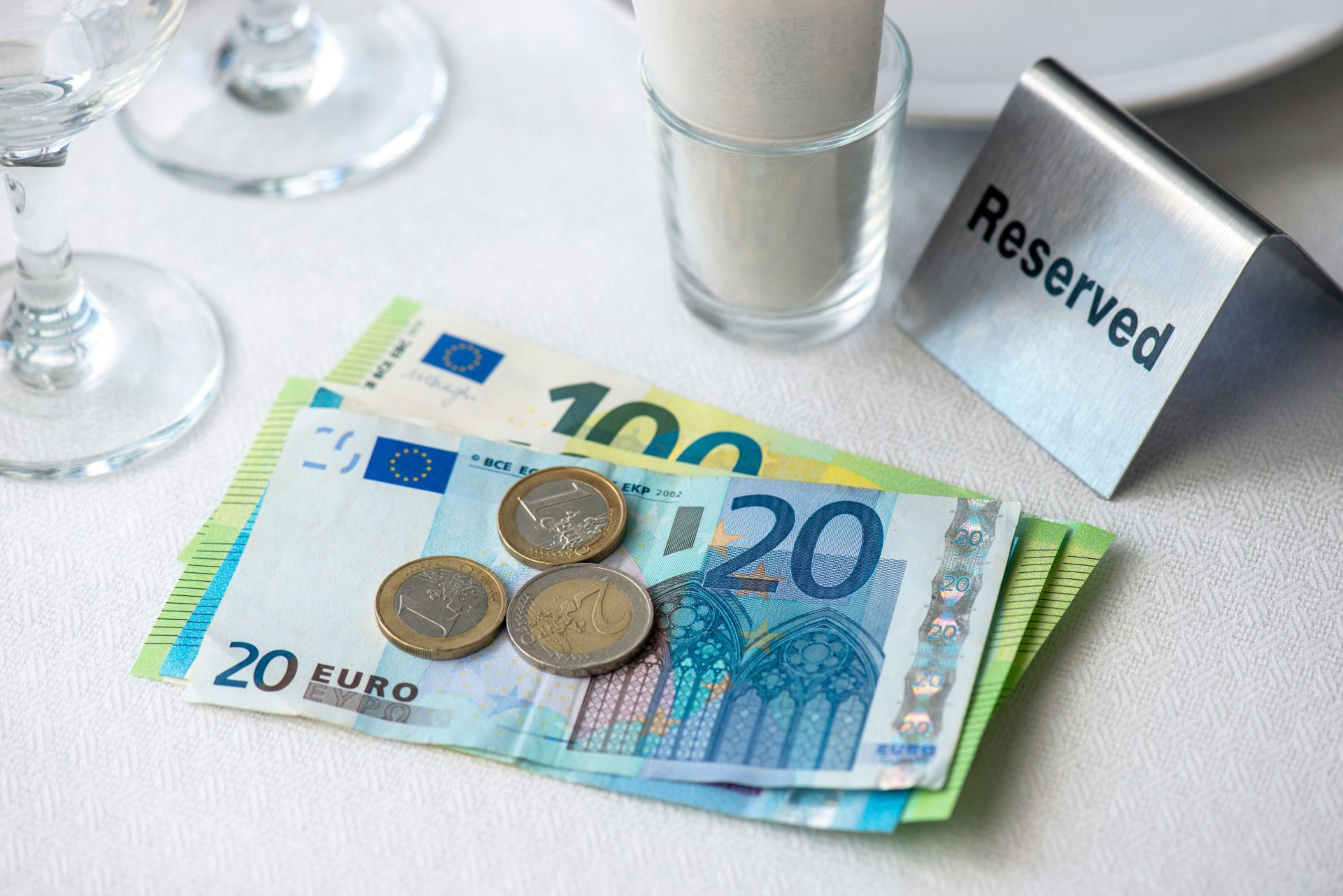 European union currency on a table with receipt bill, wine glasses, plate in restaurant in Europe