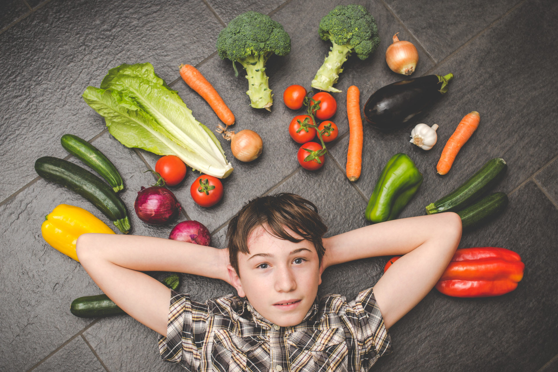 Child surrounded by vegetables 