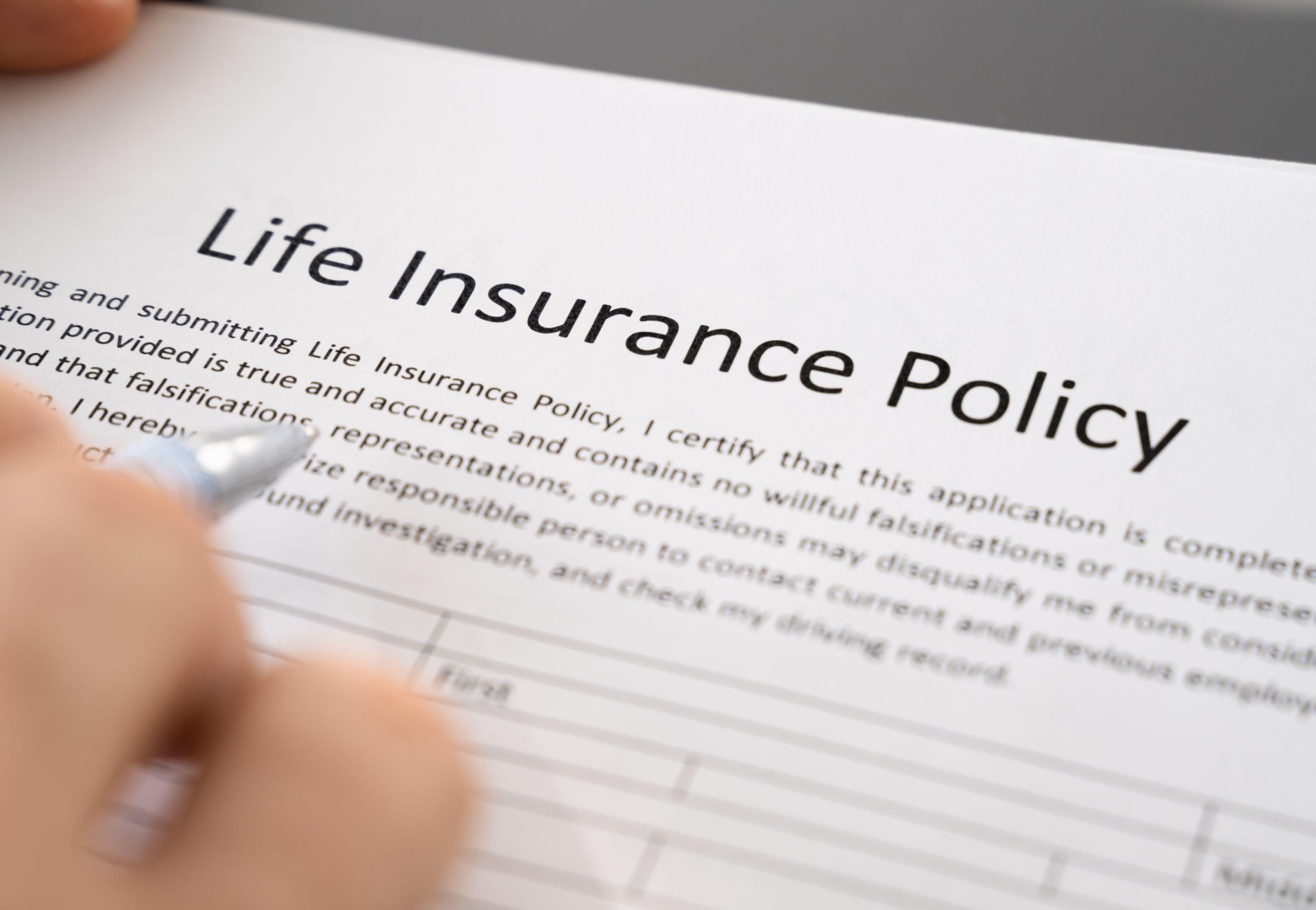 A person fills out a life insurance policy application