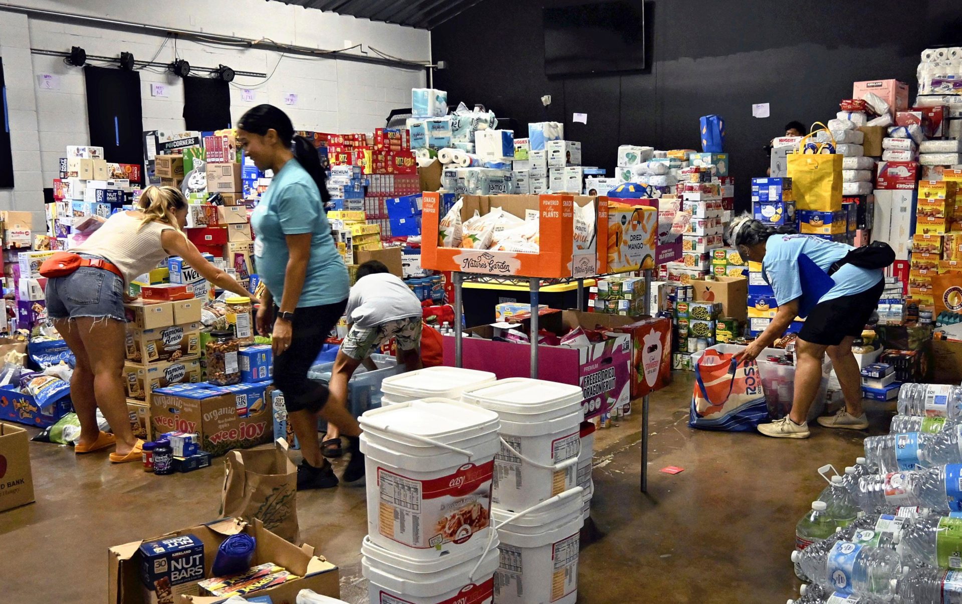 Volunteers sort relief supplies at a church which is a temporary shelter in Kahului, Maui, 