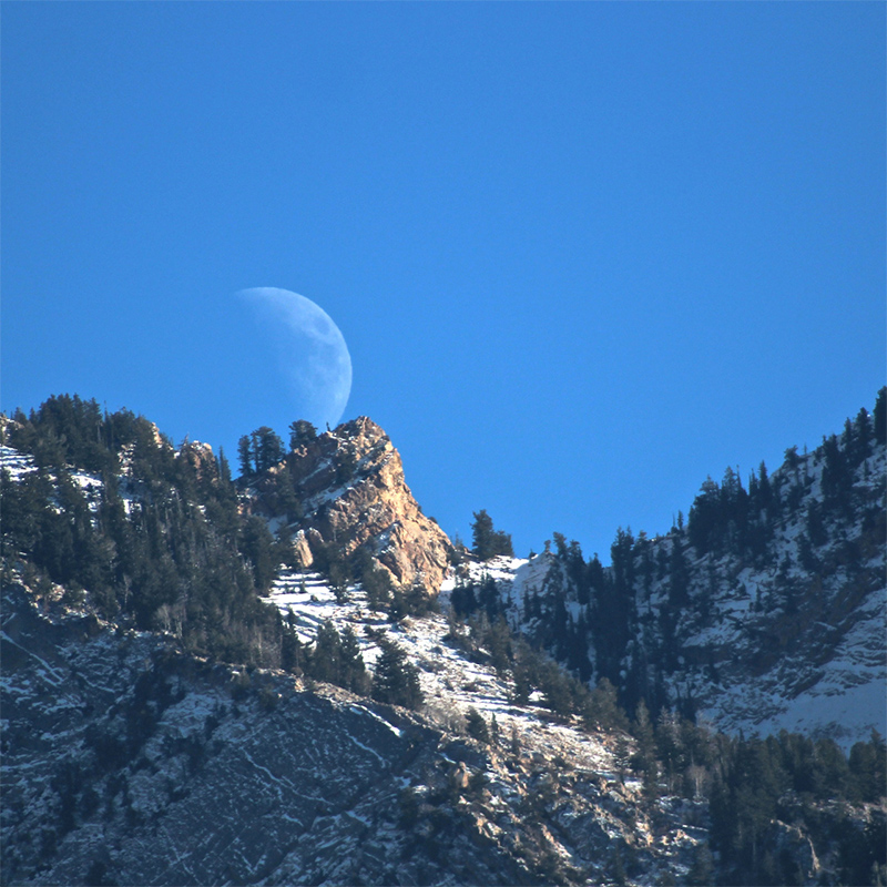 The Moon rises over a ridge in the Wasatch Mountains, Utah, USA in May 2021.