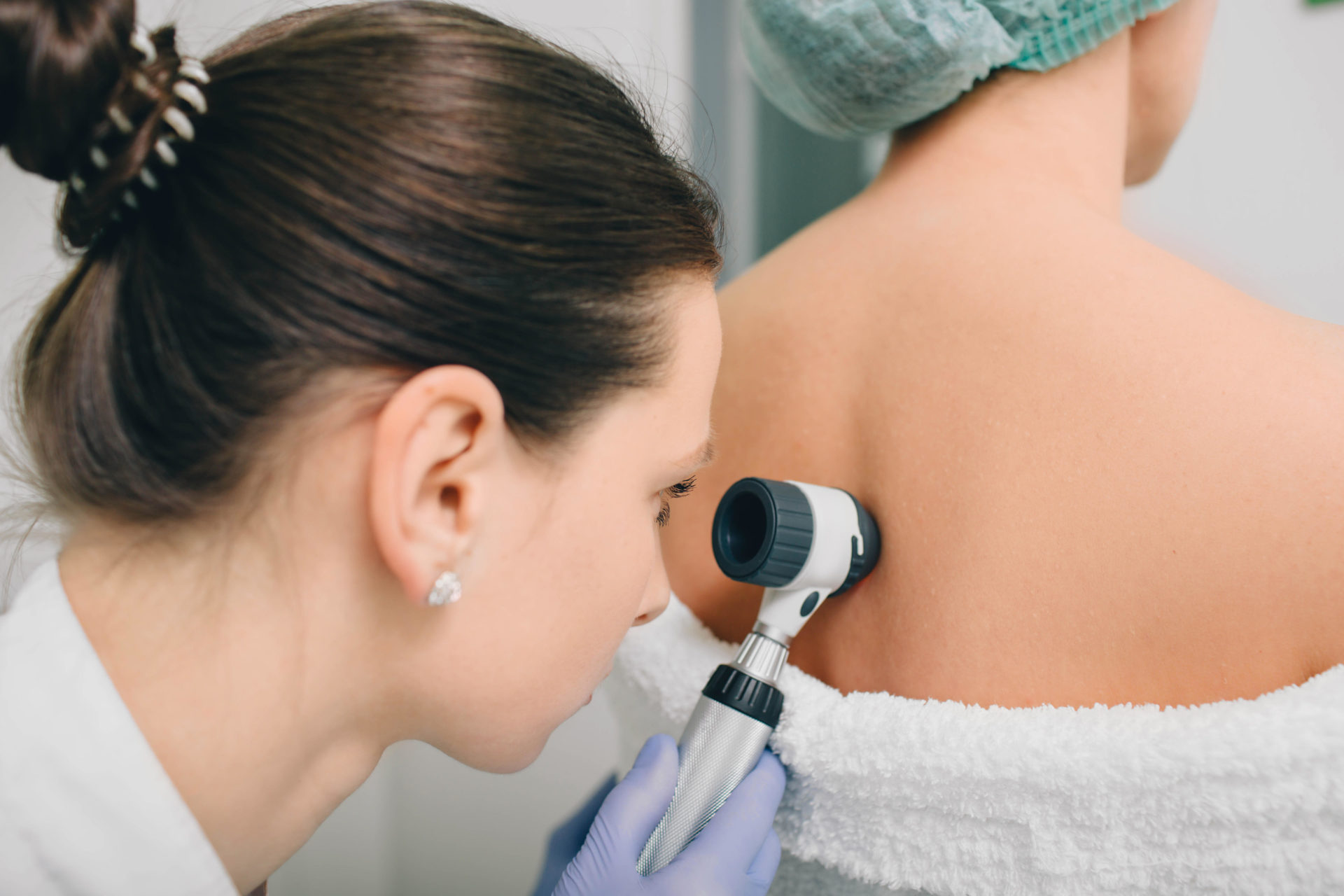 Dermatologist examines birthmarks with a dermatoscope 