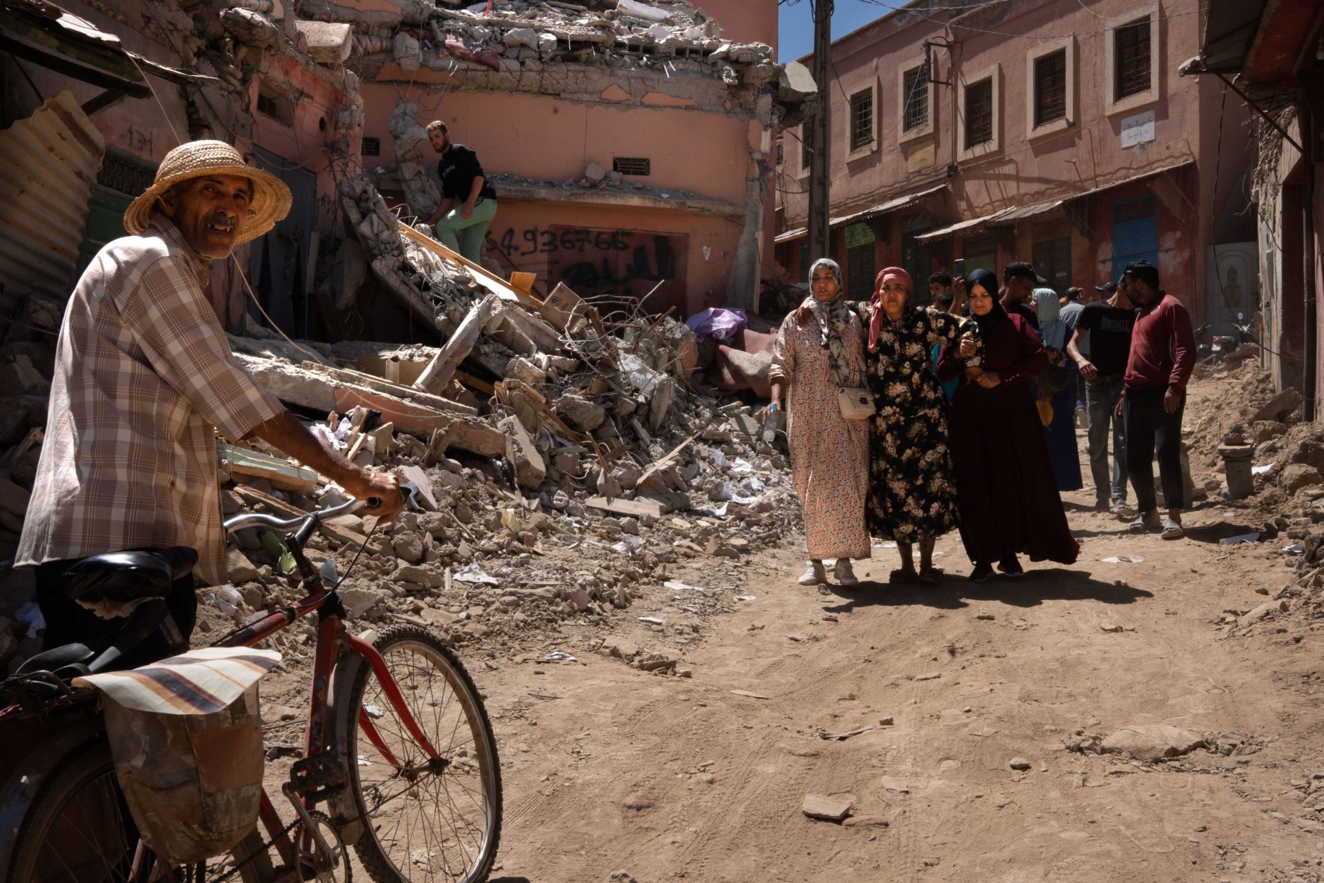 Two women carry another injured woman in front of a house destroyed by the earthquake in the city of Azizmiz. Credit: SOPA Images Limited/Alamy Live News