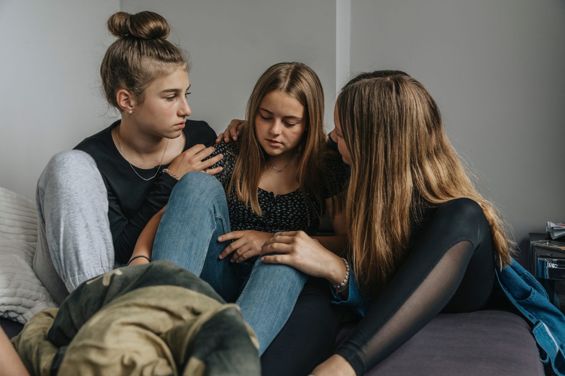 Girlfriends consoling sad teenage girl (Westend61 GmbH / Alamy Stock Photo)