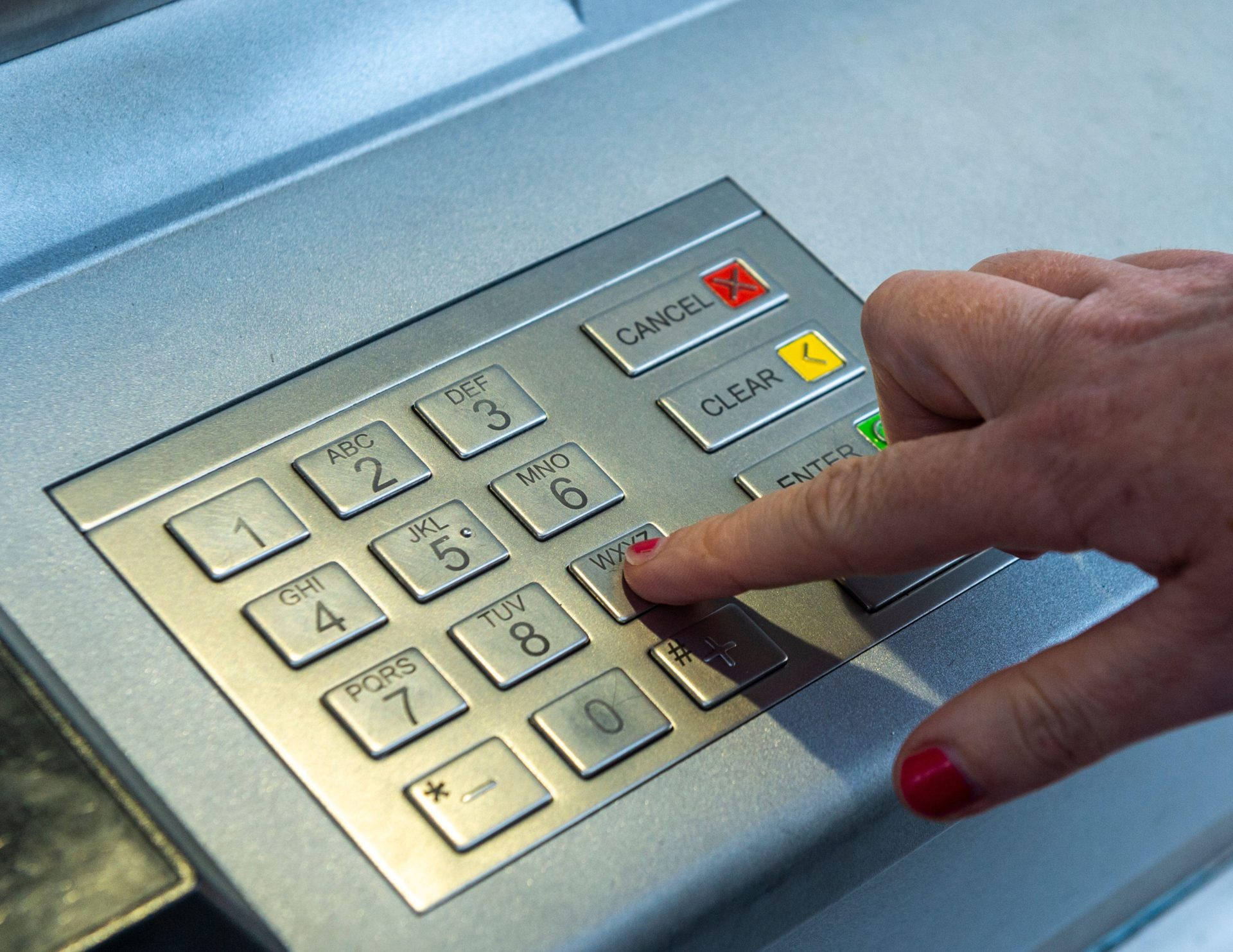 A woman entering her PIN into an ATM in September 2020.