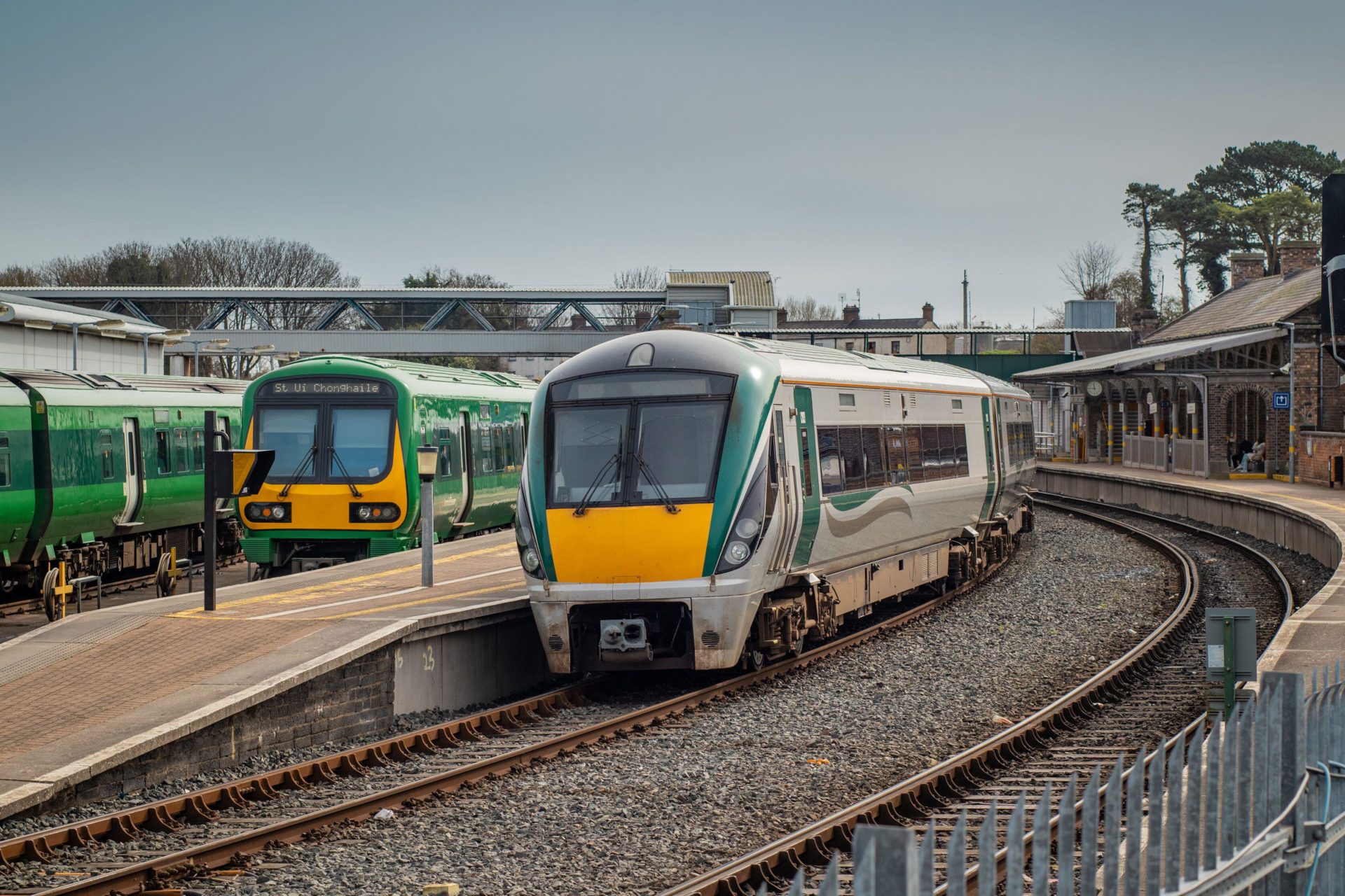 2RMY5R1 Trains on Drogheda macbride train station in ireland, on a line from Dublin to Belfast. Rail platforms and trains passing by on a sunny day.