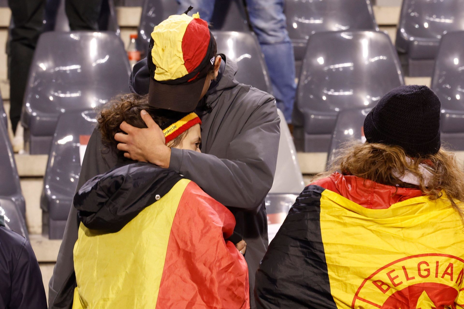 A supporter is comforted on the stands after suspension of the Euro 2024 group F qualifying soccer match between Belgium and Sweden