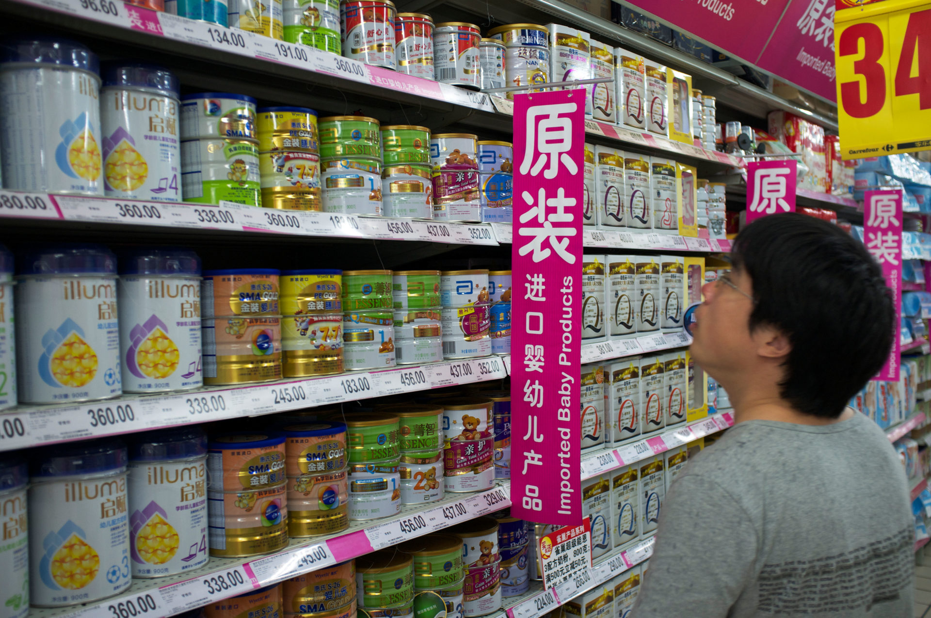 DAA2TD A man looks at imported infant formula baby milk powder in a supermarket in Beijing, China. 09-Jul-2013