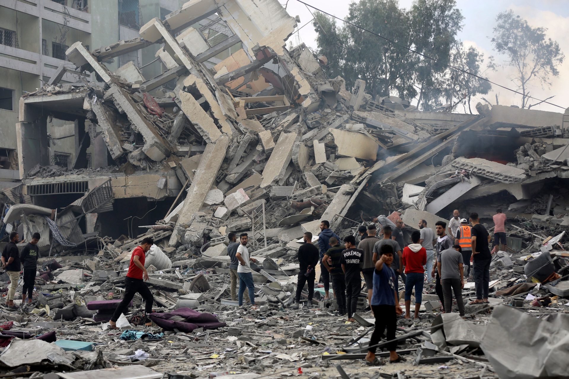 Palestinians inspect the damage of a destroyed building following Israeli airstrikes on Gaza City