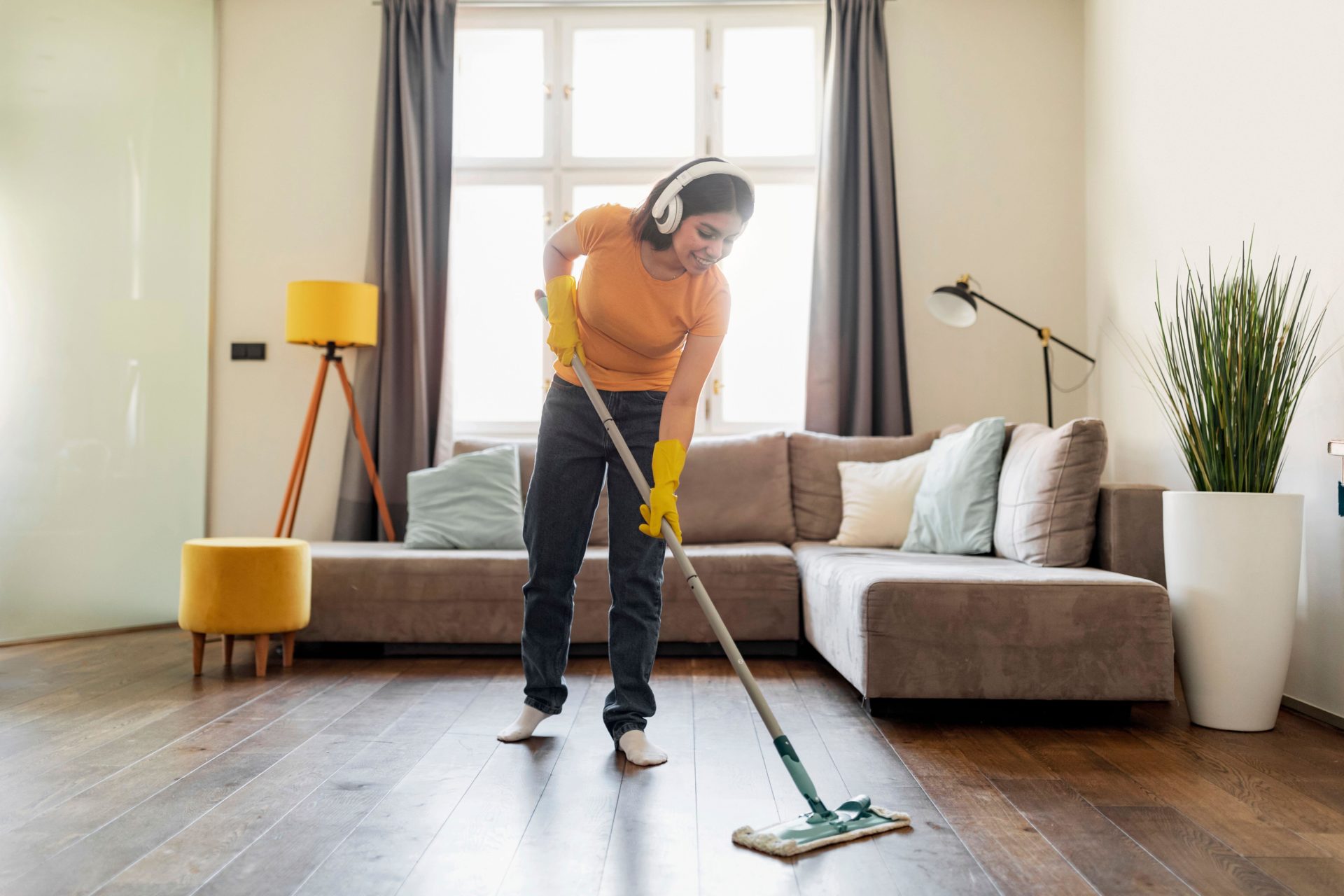 Young woman cleaning room. Image: Prostock-studio / Alamy Stock Photo 