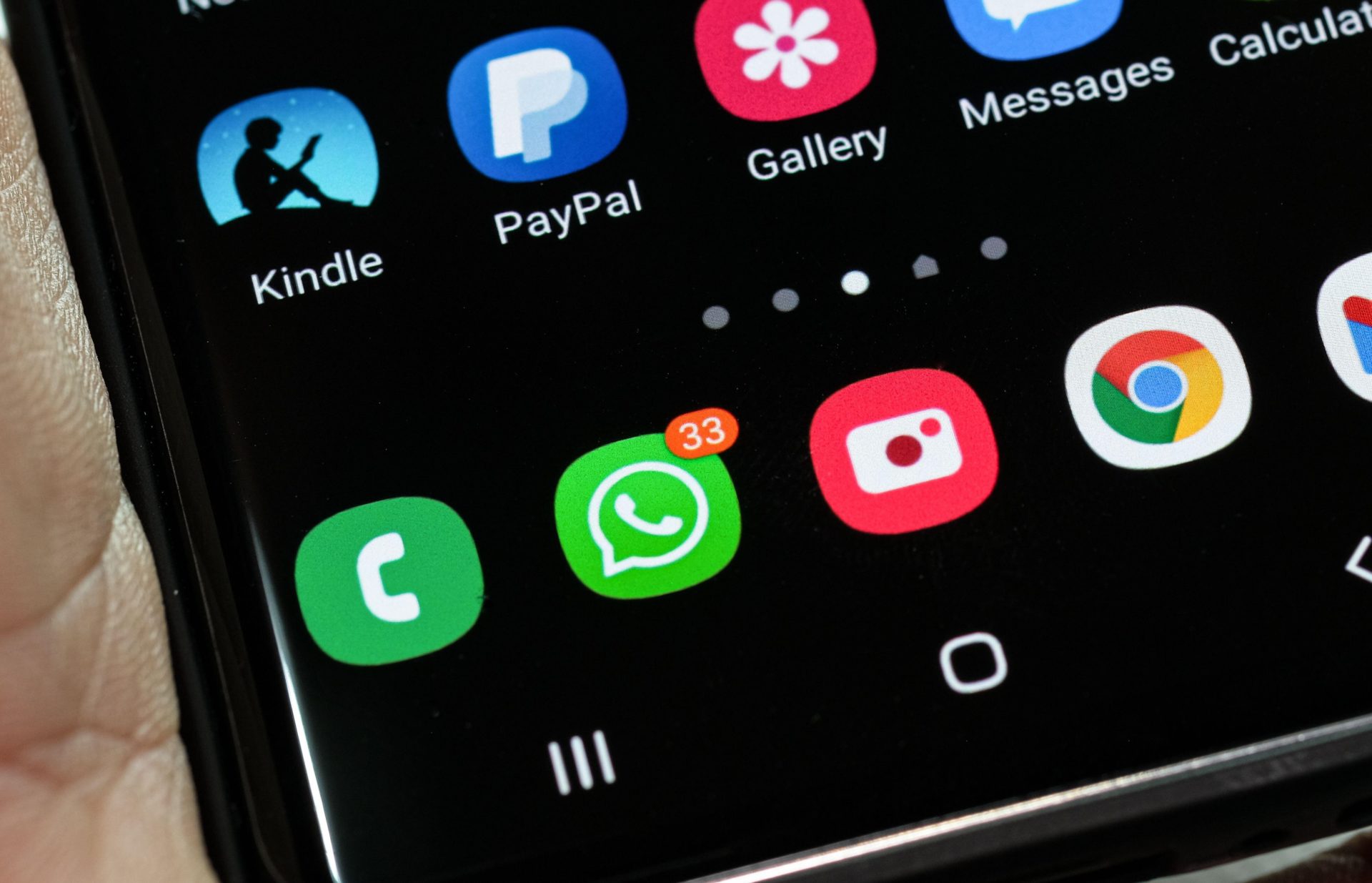 A WhatsApp icon on a smartphone showing message notifications, 2-4-21.