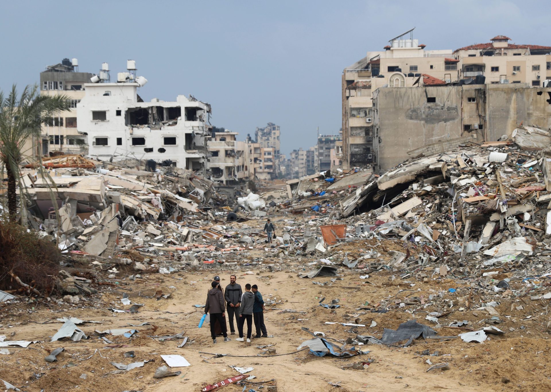Palestinians walk past a building destroyed in the Israeli bombardment of the Gaza Strip in Gaza City, 3-1-24.