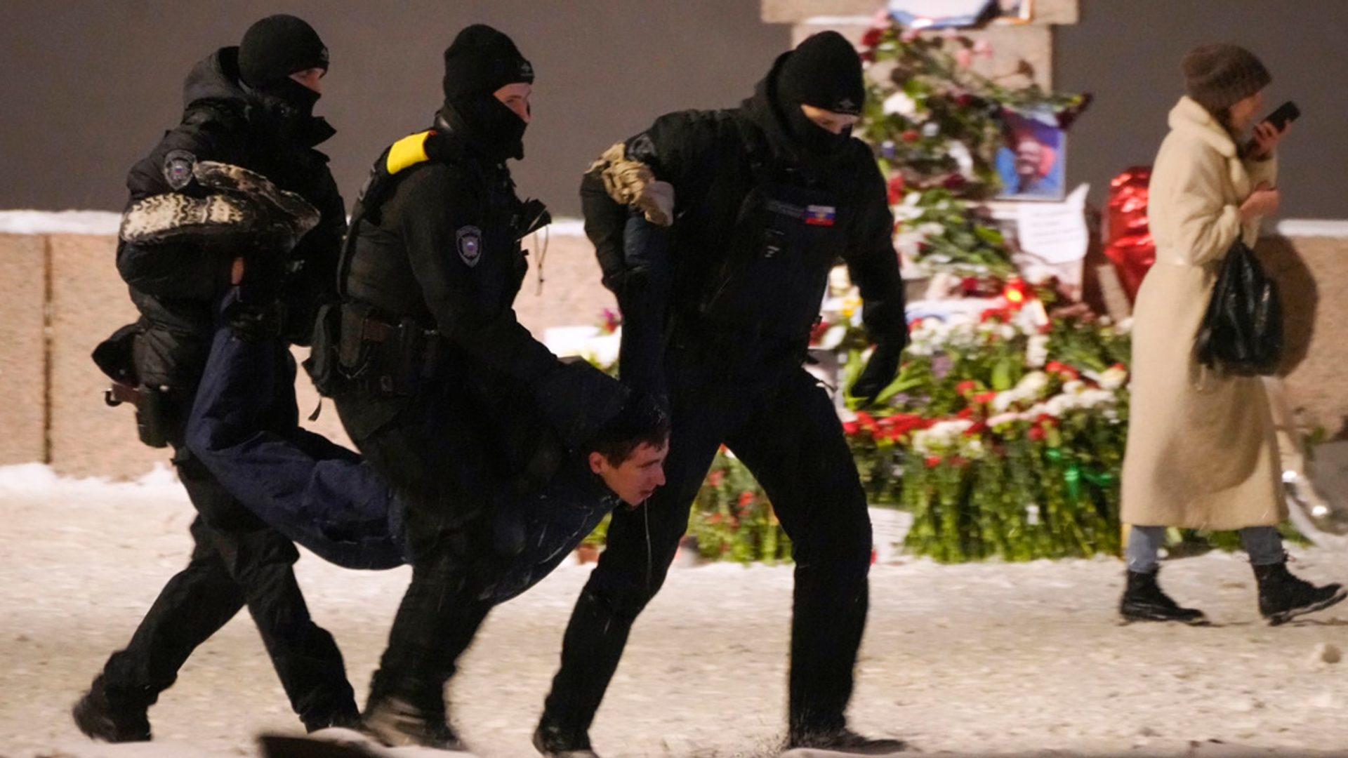 Police detain a man leaving flowers at a memorial for Alexei Navalny, 16/02/2024. Image: AP/Alamy