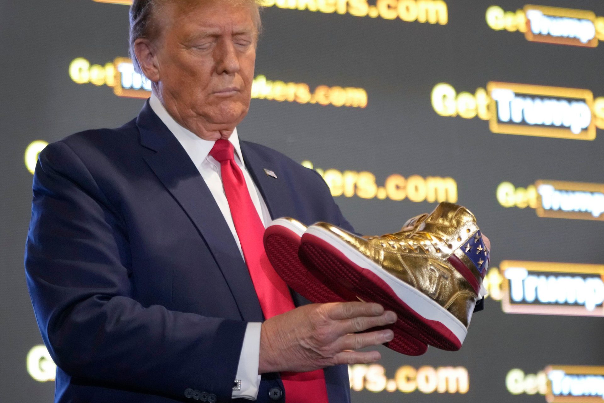 Former US President Donald Trump holds gold Trump sneakers at Sneaker Con Philadelphia, 17-2-24. 