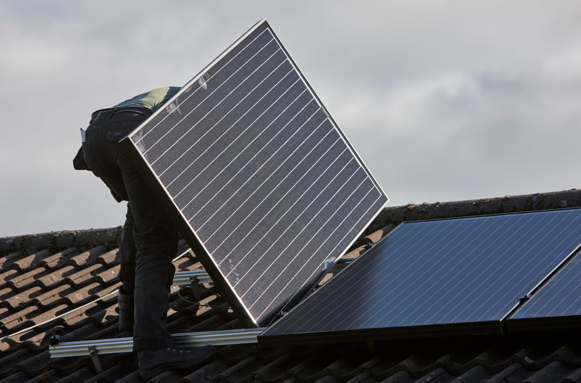 A man installing rooftop solar panels, 20-9-16.