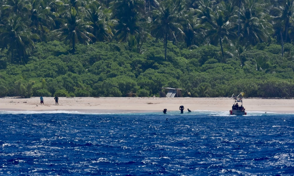 Rescuers reach the three stranded sailors on a remote Pacific island