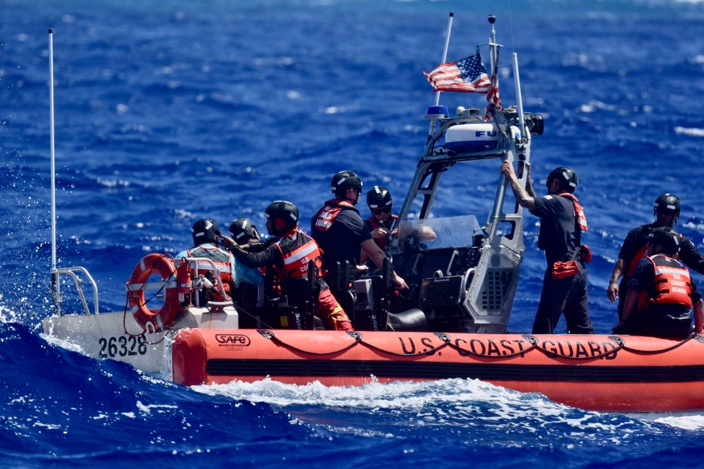 Rescuers reach the three stranded sailors on a remote Pacific island