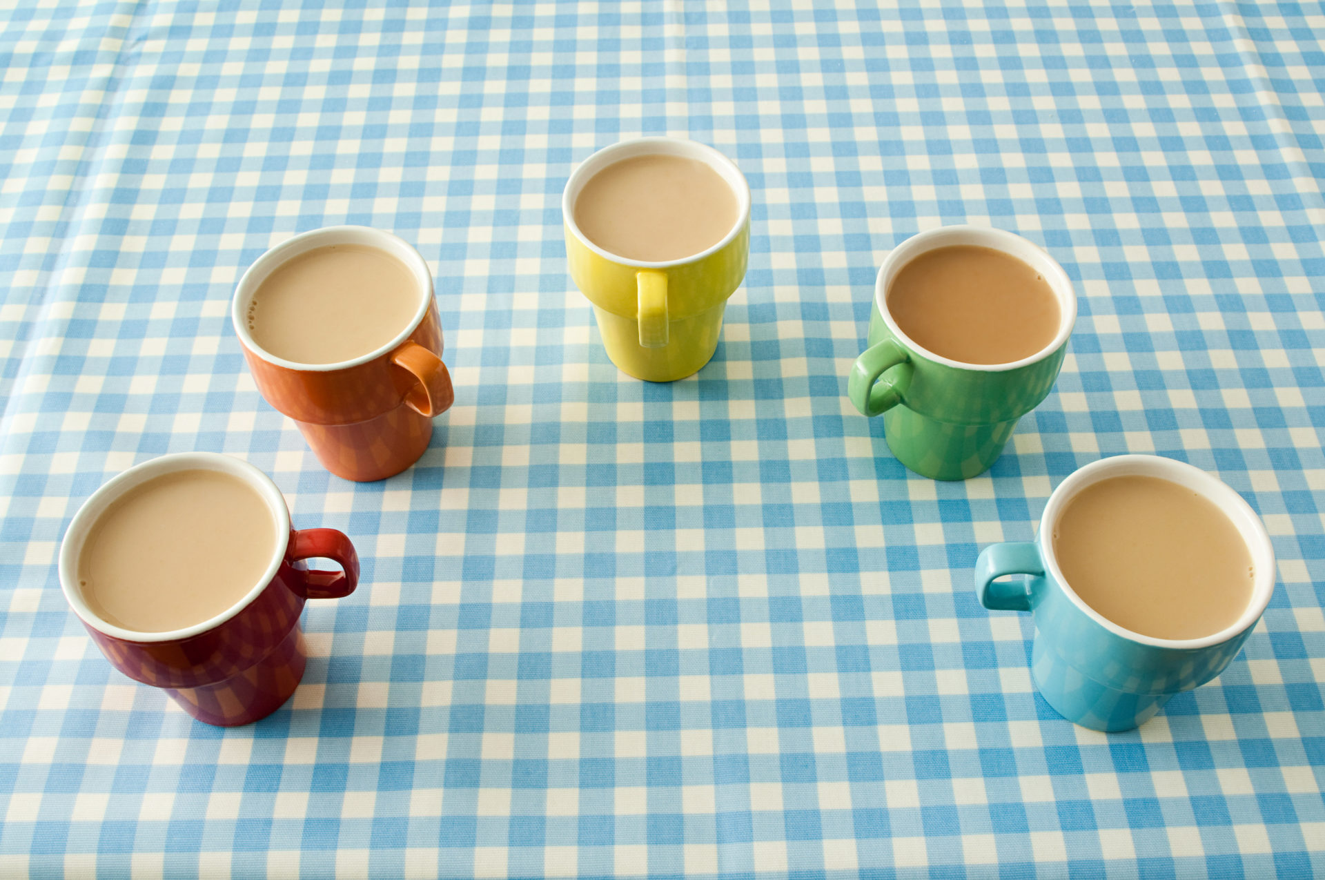 Five cups of tea making a U shape on a table.