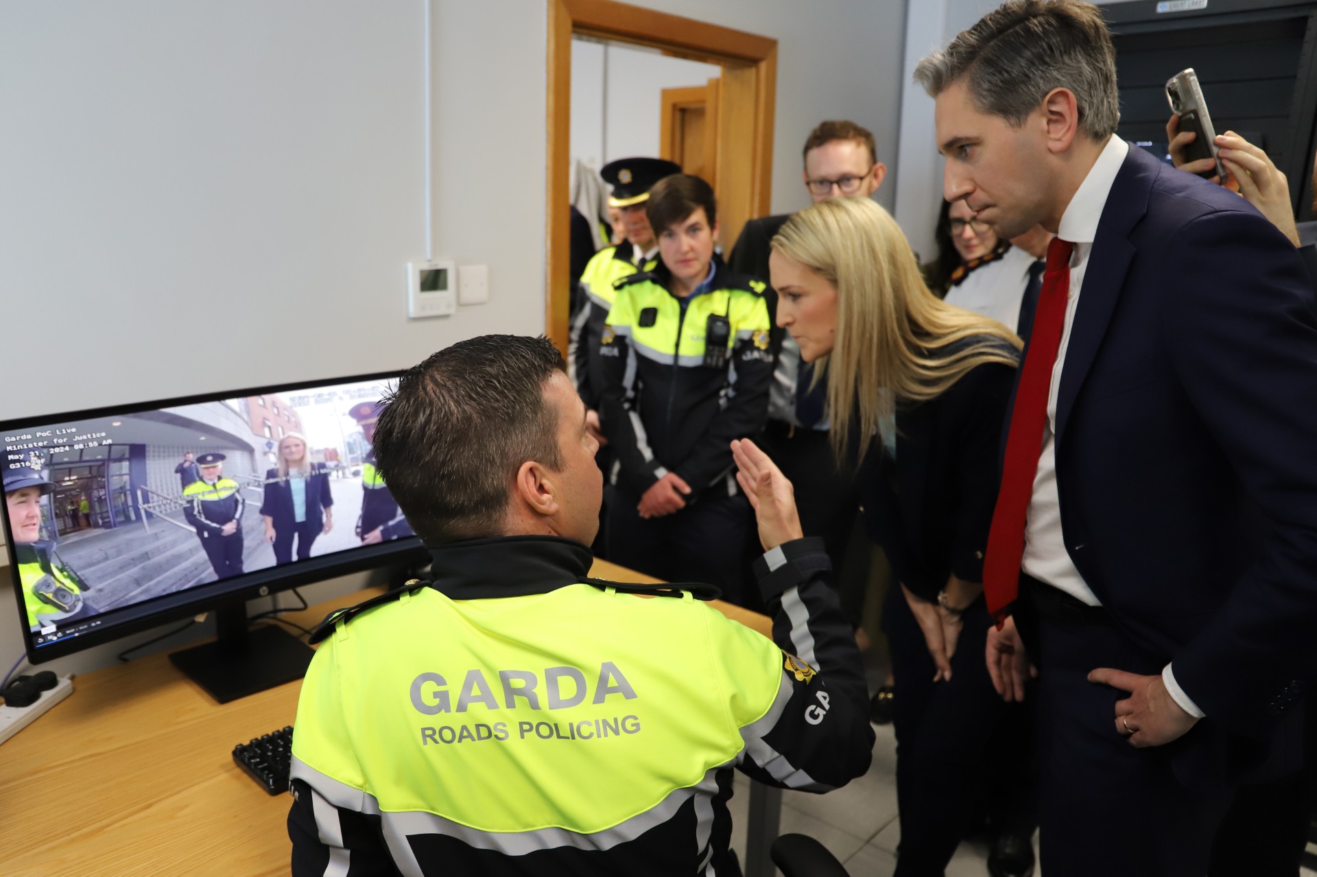 Helen McEntee and Simon Harris inspecting footage taken of them using bodycams. Image: An Garda Síochána