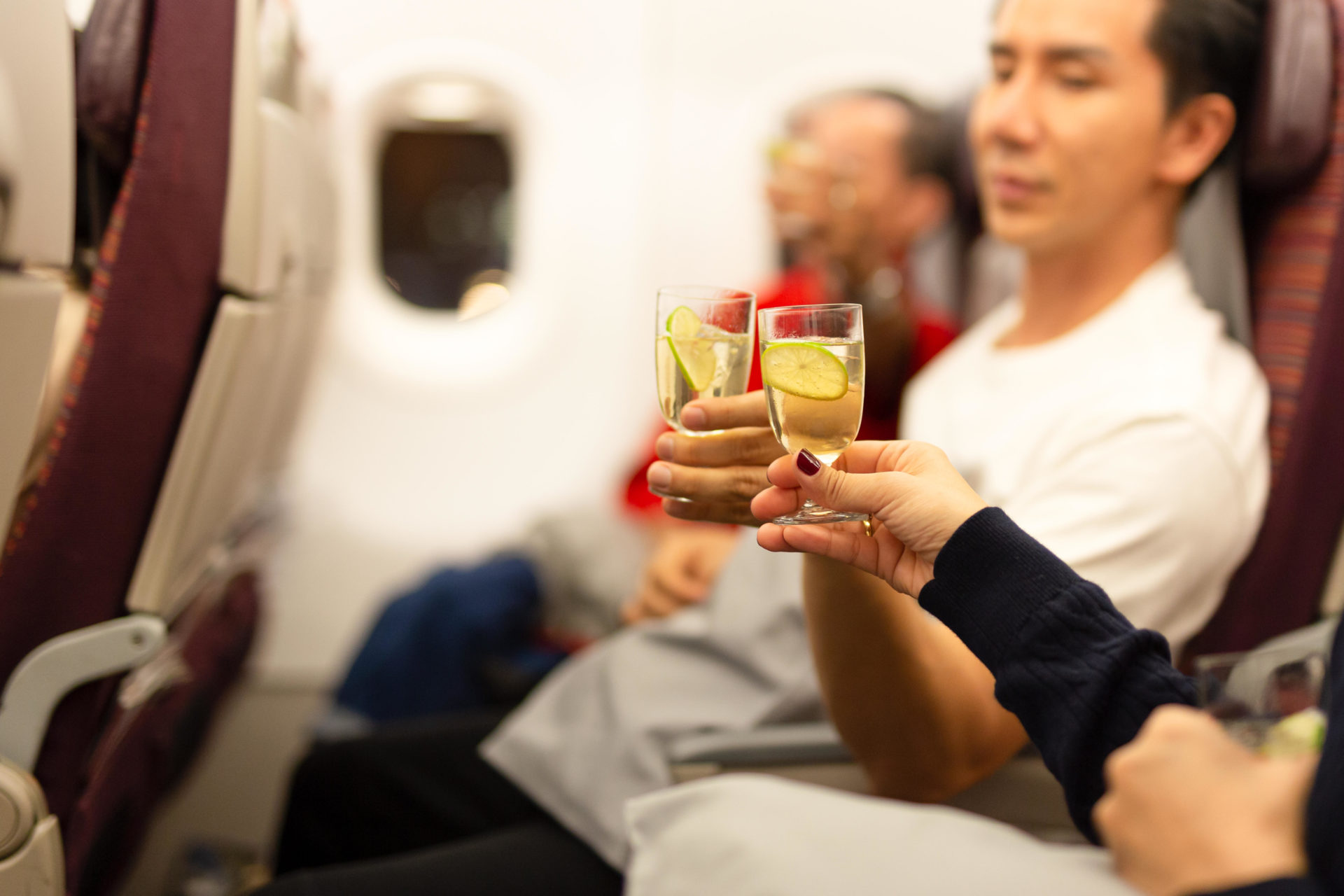 Passengers toasting alcohol on flight. Image: suwinai sukanant / Alamy Stock Photo 