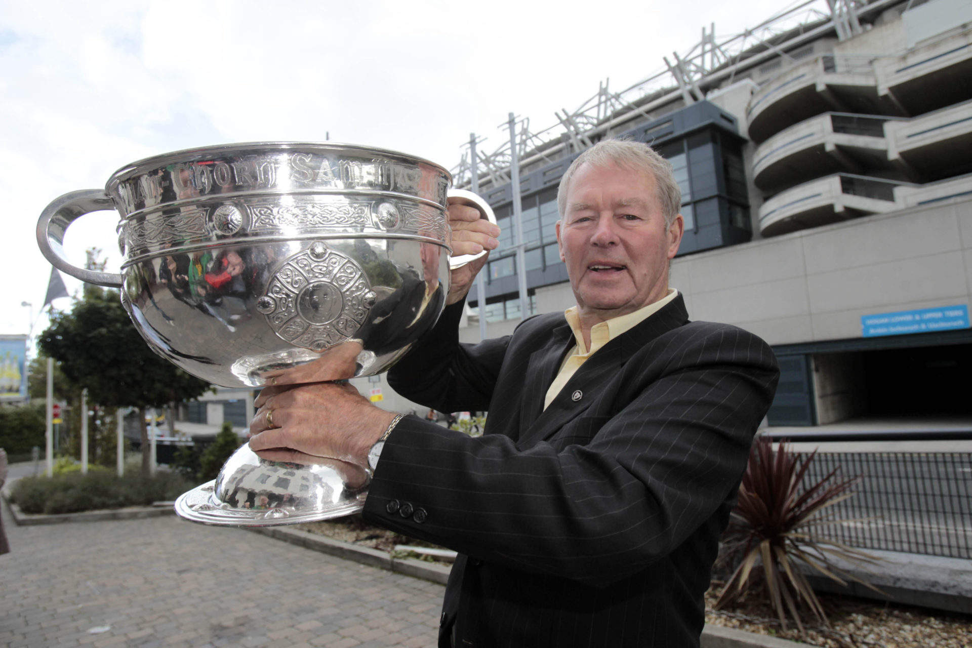 Legendary GAA commentator Mícheál Ó Muircheartaigh holds the Sam Maguire Cup outside Croke Park in Dublin after announcing his retirement in 2010