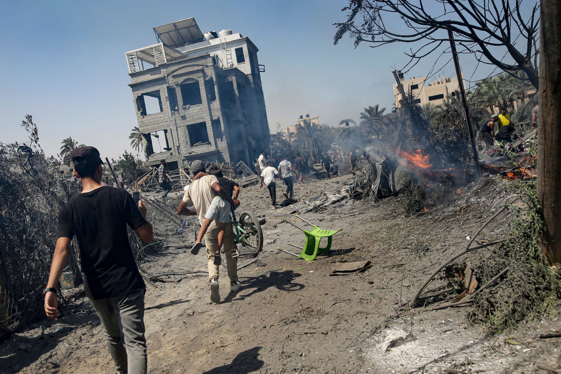 Palestinians evacuate from a site hit by an Israeli bombardment on Khan Younis, southern Gaza Strip. Image: AP Photo/Jehad Alshrafi