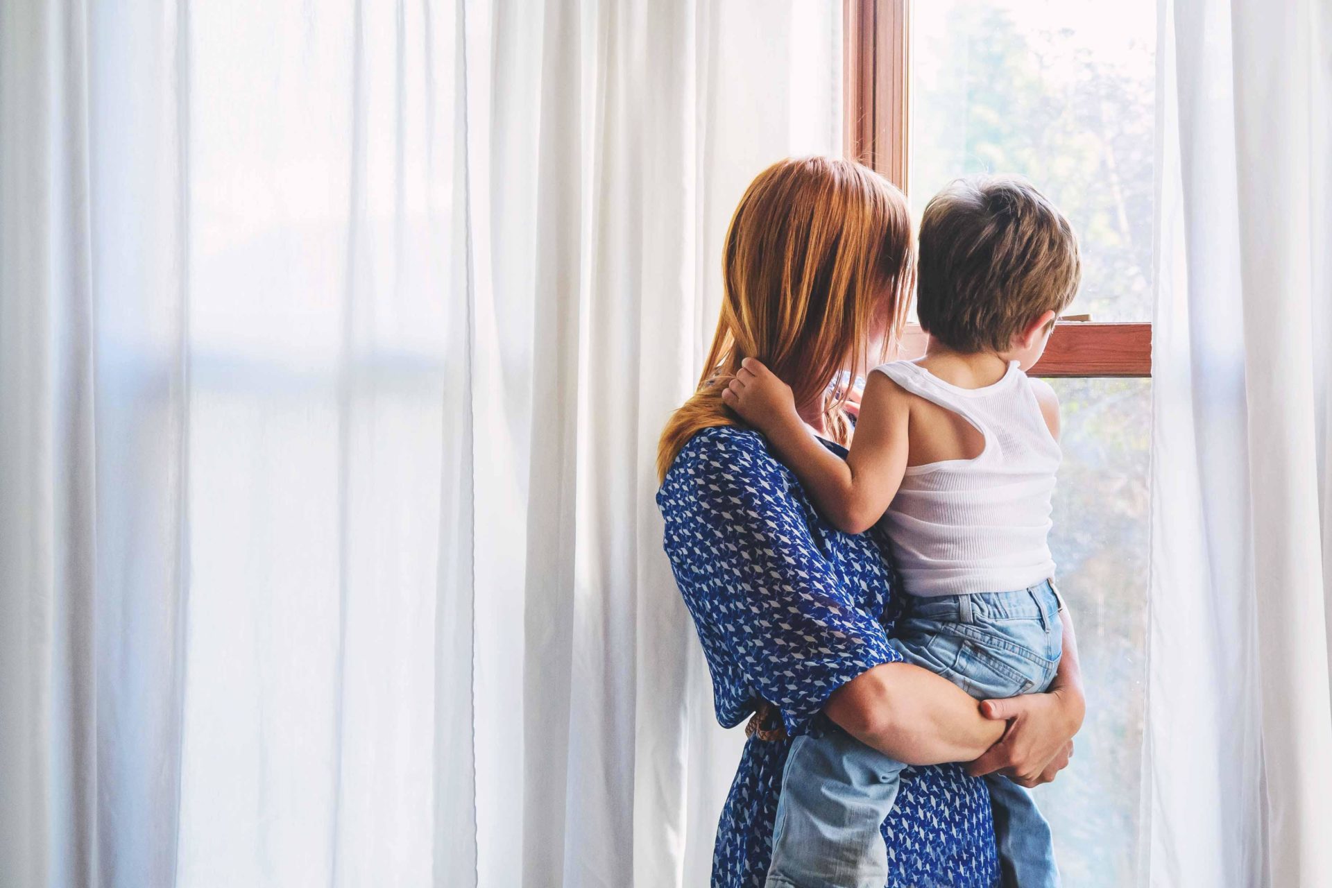 Mother and her son and looking through a window