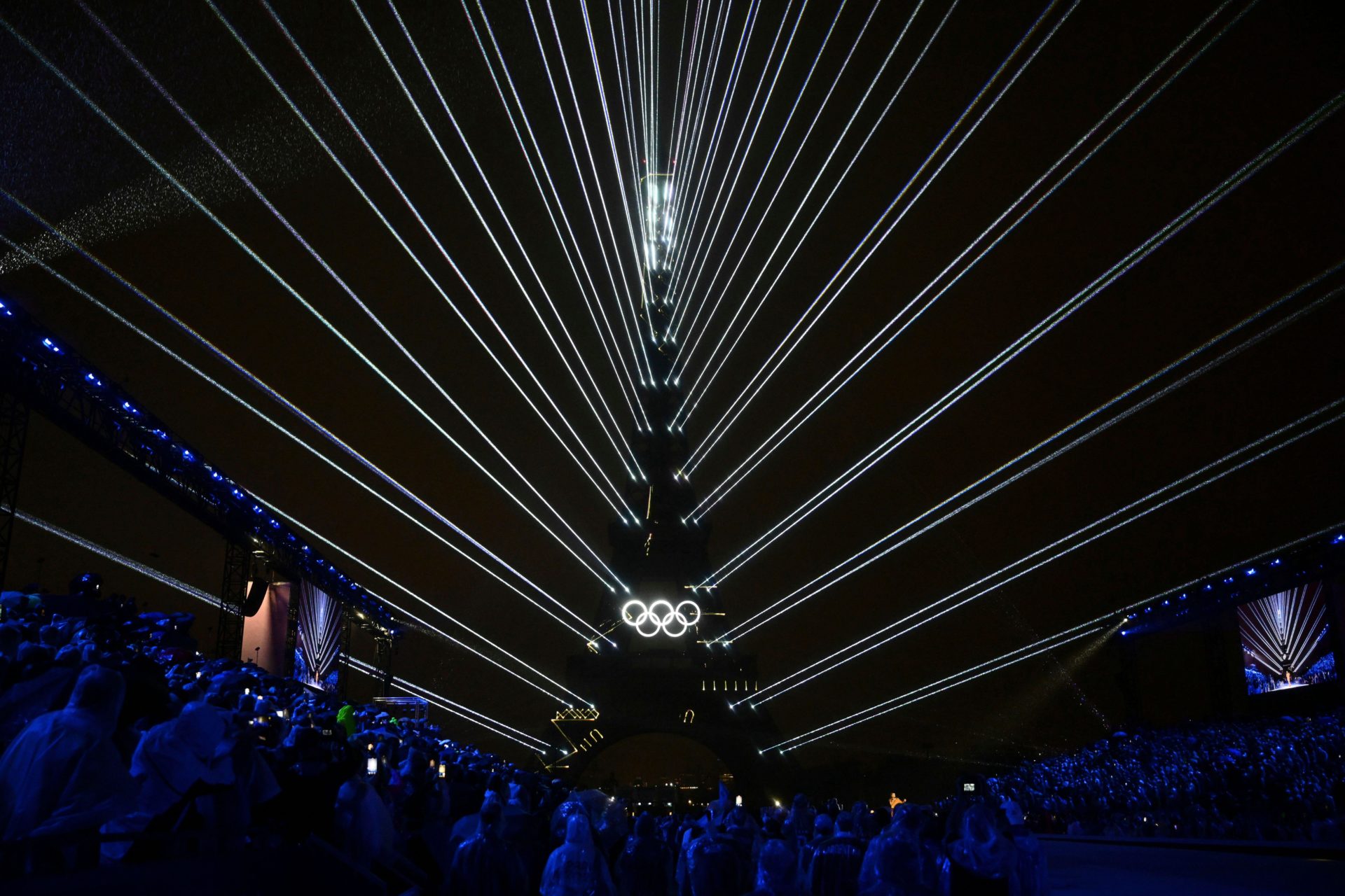 The Olympic rings are illuminated as lights emanate from the Eiffel Tower at the Trocadero during the opening ceremony for the 2024 Summer Olympics in Paris, France, Friday, July 26, 2024. (Loic Venance/Pool Photo via AP)