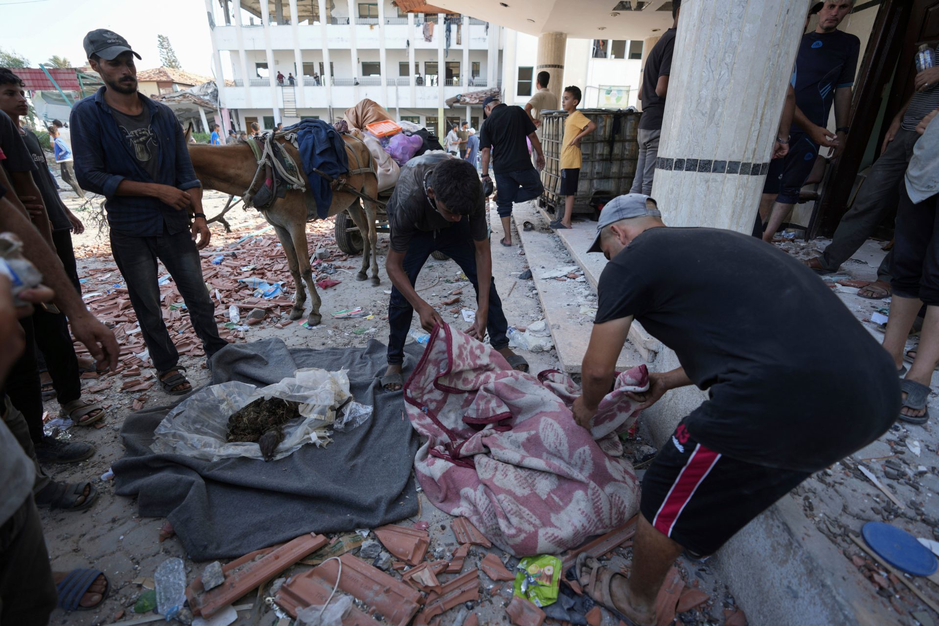 Palestinians search for bodies in the rubble of a school destroyed in an Israeli airstrike on Deir al-Balah, central Gaza Strip, 27/07/2024. (AP Photo/Abdel Kareem Hana)