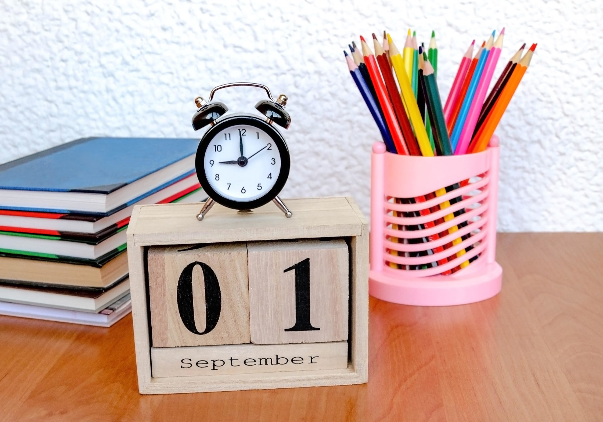 School clock on top of wooden calendar. Image: ALLASH / Alamy Stock Photo