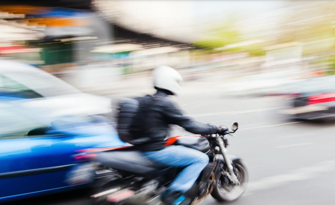 A motorcyclist moves through traffic