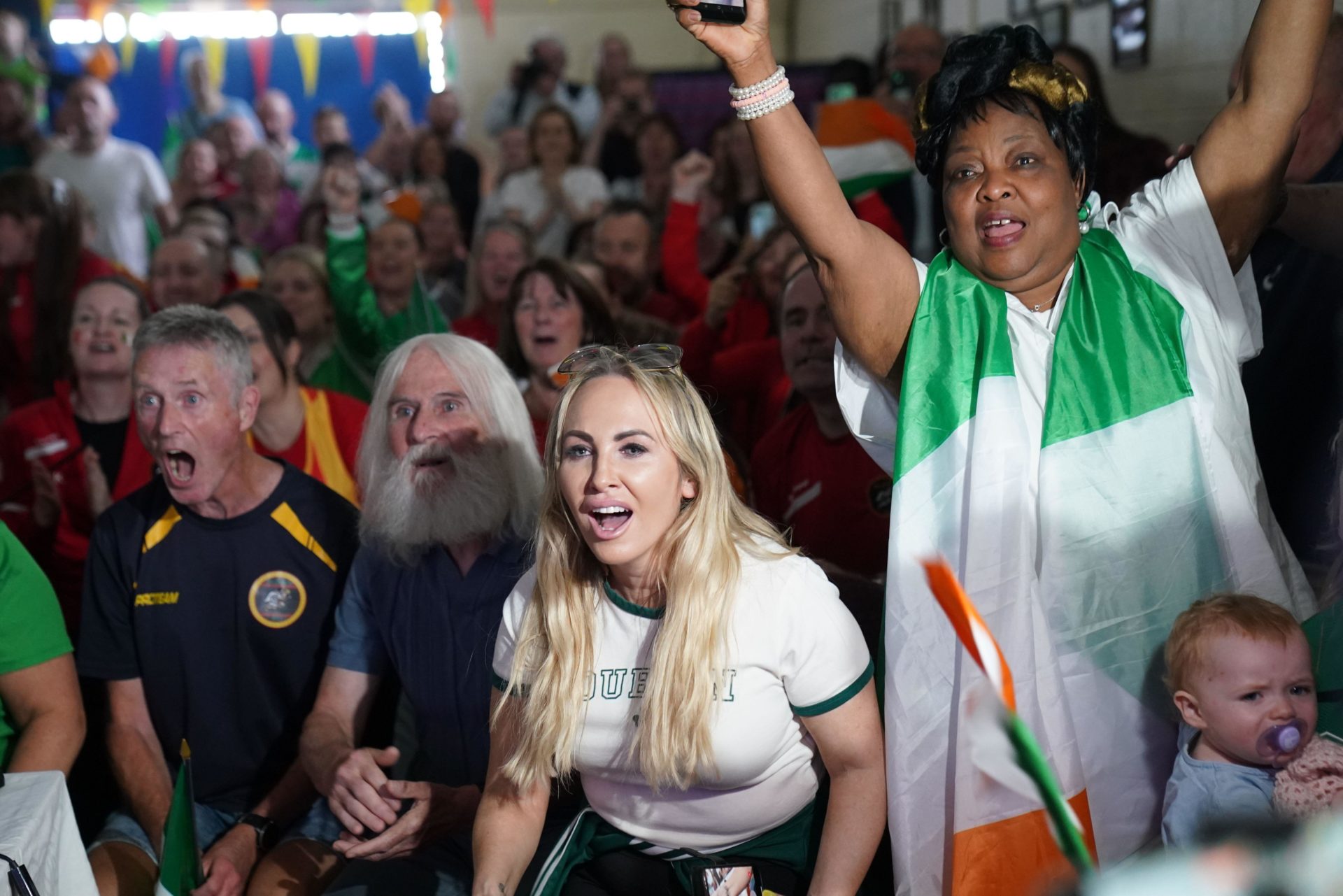 Supporters of Team Ireland athlete Rhasidat Adeleke, attending a watch party ahead of her taking part in the Women's 400m final at Tallaght Athletics Club, 09/08/2024. Image: PA Images/Alamy