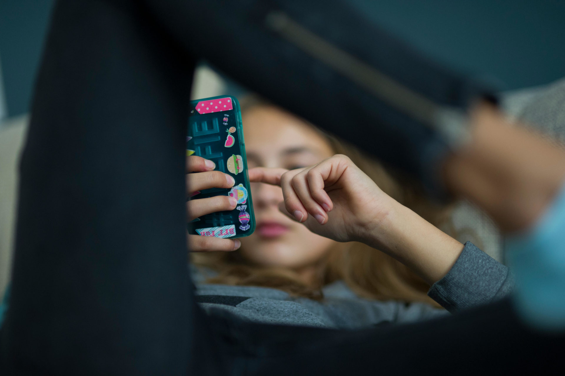 A teenage girl relaxing looking at a smartphone, 19-9-15