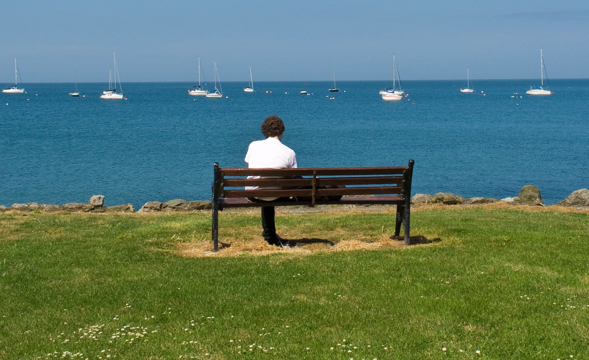 Tackling loneliness: A man sitting on a bench overlooking the bay at Skerries in Dublin