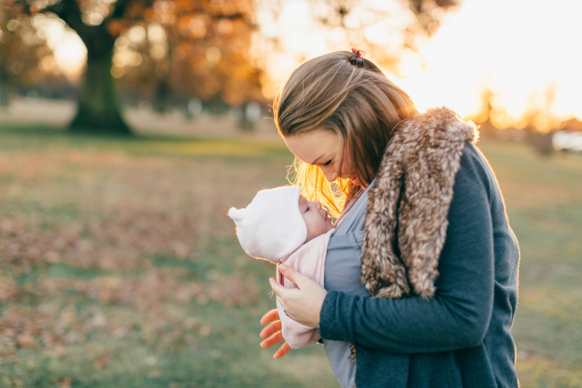 A mother carrying a baby in a sling