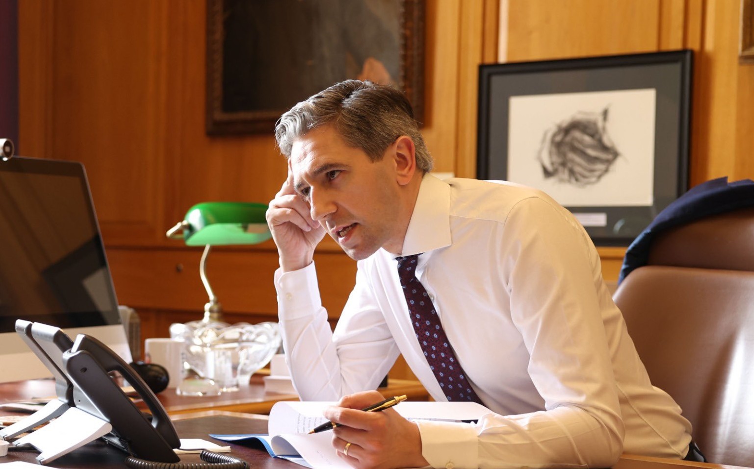 Taoiseach Simon Harris speaking on the phone from his office at Government Buildings in Dublin, 15-5-24.