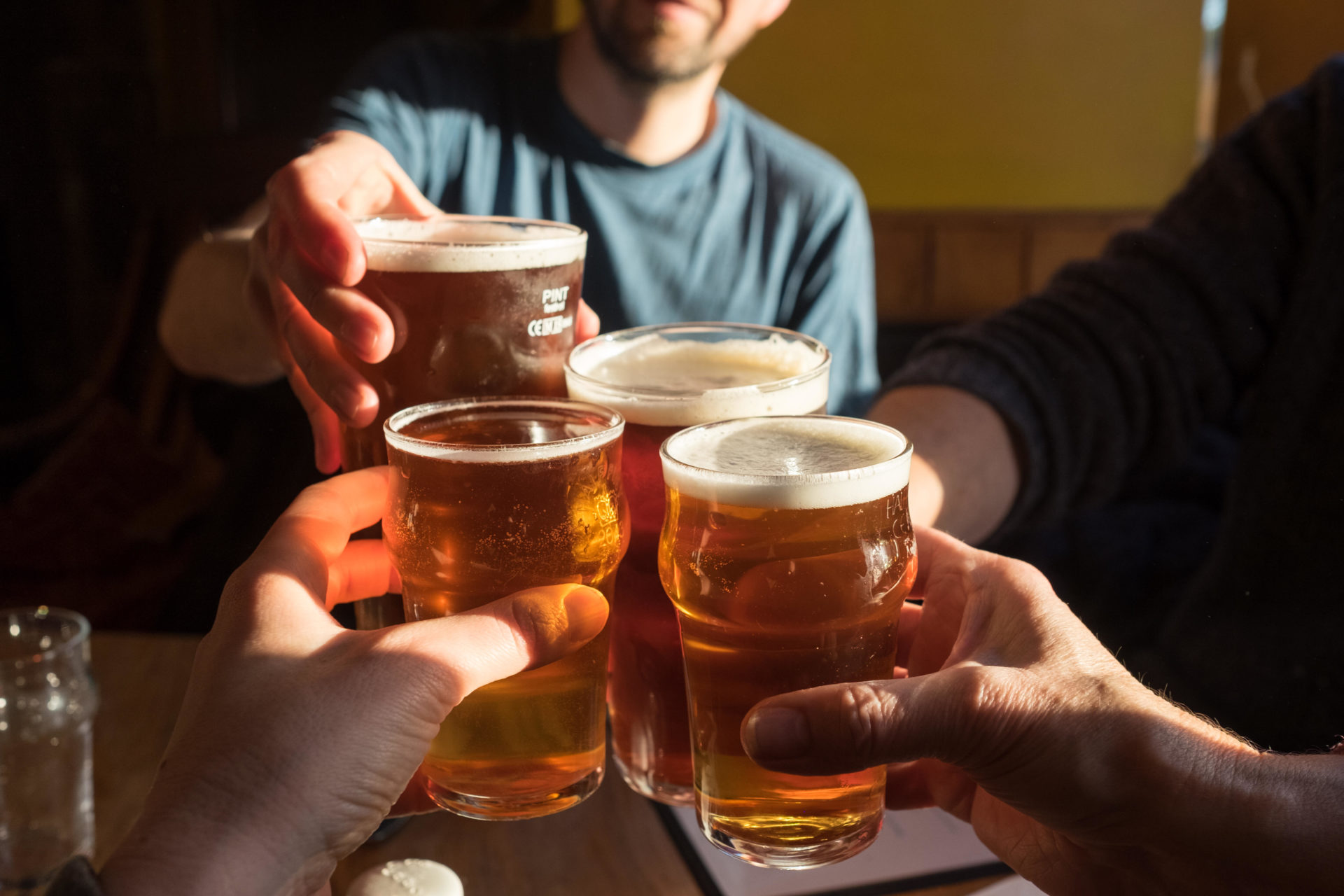 A party of four clink glasses (2 pints of cask ale and 2 half pints of cider) and say cheers at The Black Bull Inn in Frosterley, County Durham, UK.