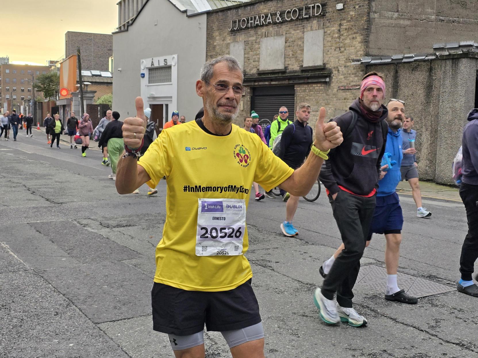 A man wearing a yellow t-shirt running in the Dublin Marathon.