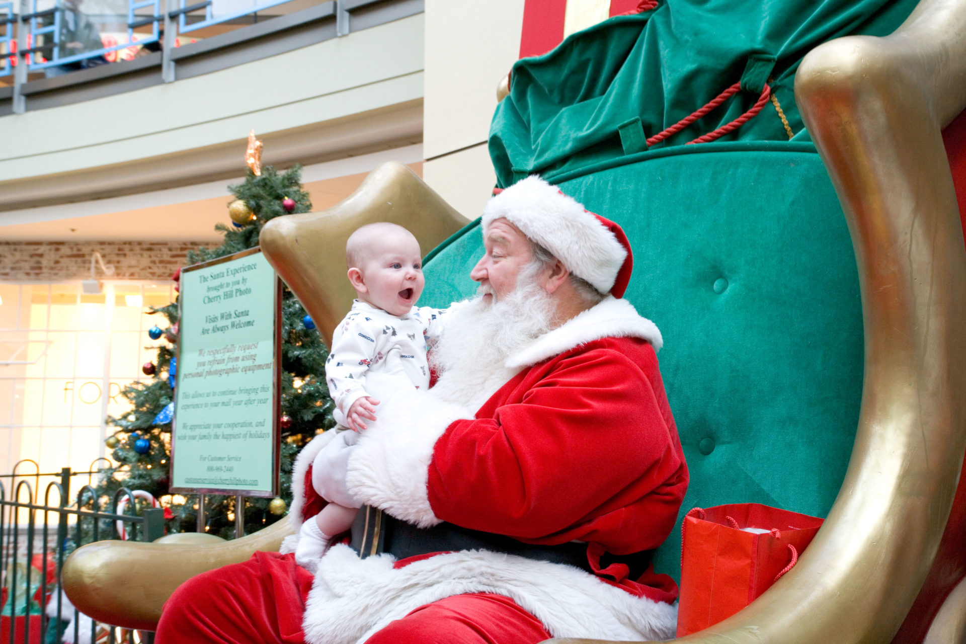 Santa Claus in a Mall with excited baby.