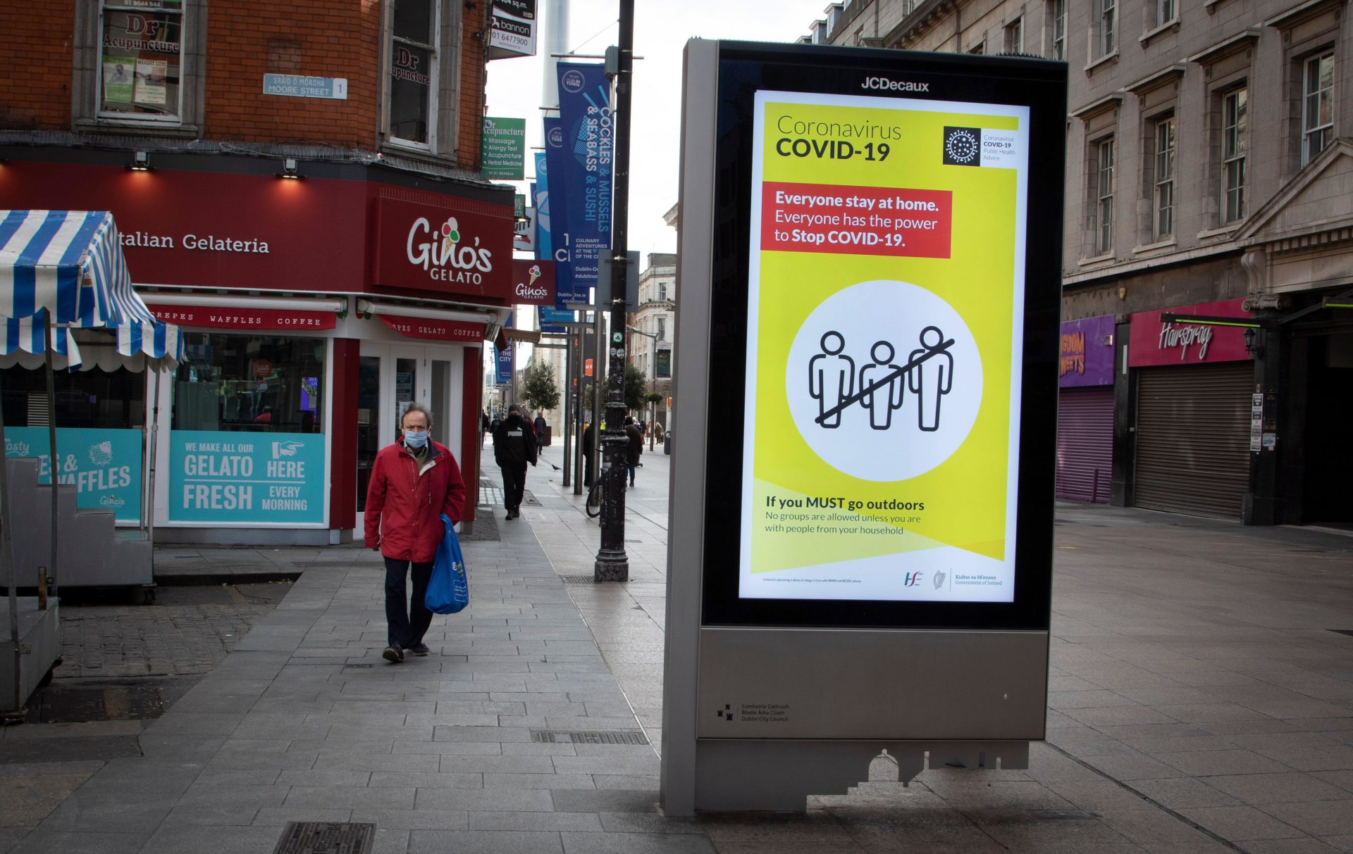 A nearly empty Henry Street during lockdowns in 2020, witha yellow social distancing notice in the centre.