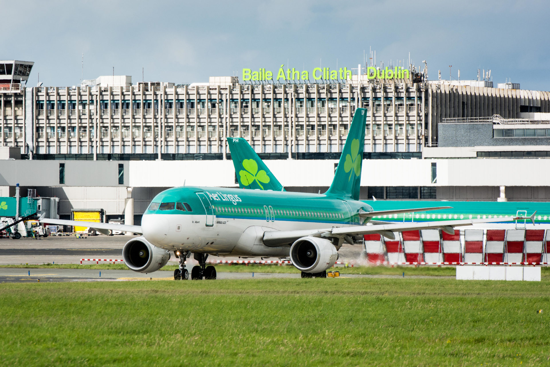 Aer Lingus plane on ground at Dublin airport with Dublin airport sign on terminal behind